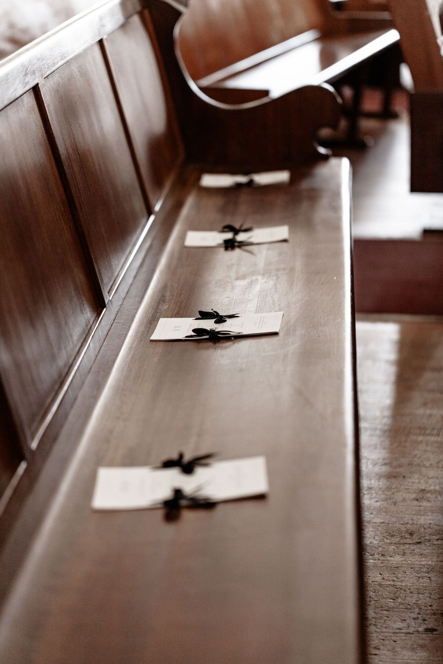 Multiple black and white photos show papers resting on a wooden table surface in sequence, creating a minimalist study.