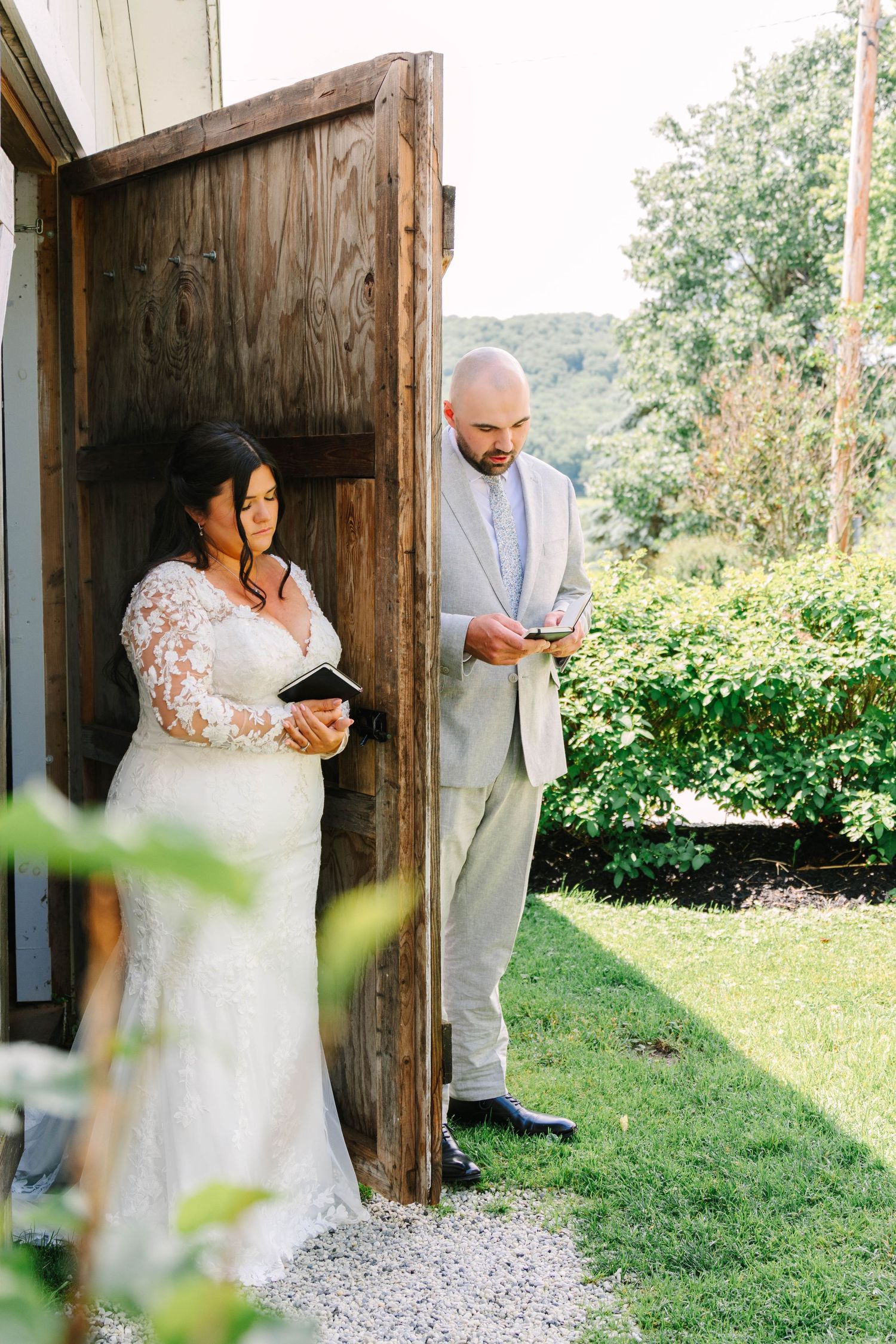 Bride and groom share private vows through a rustic wooden door before their outdoor wedding ceremony.