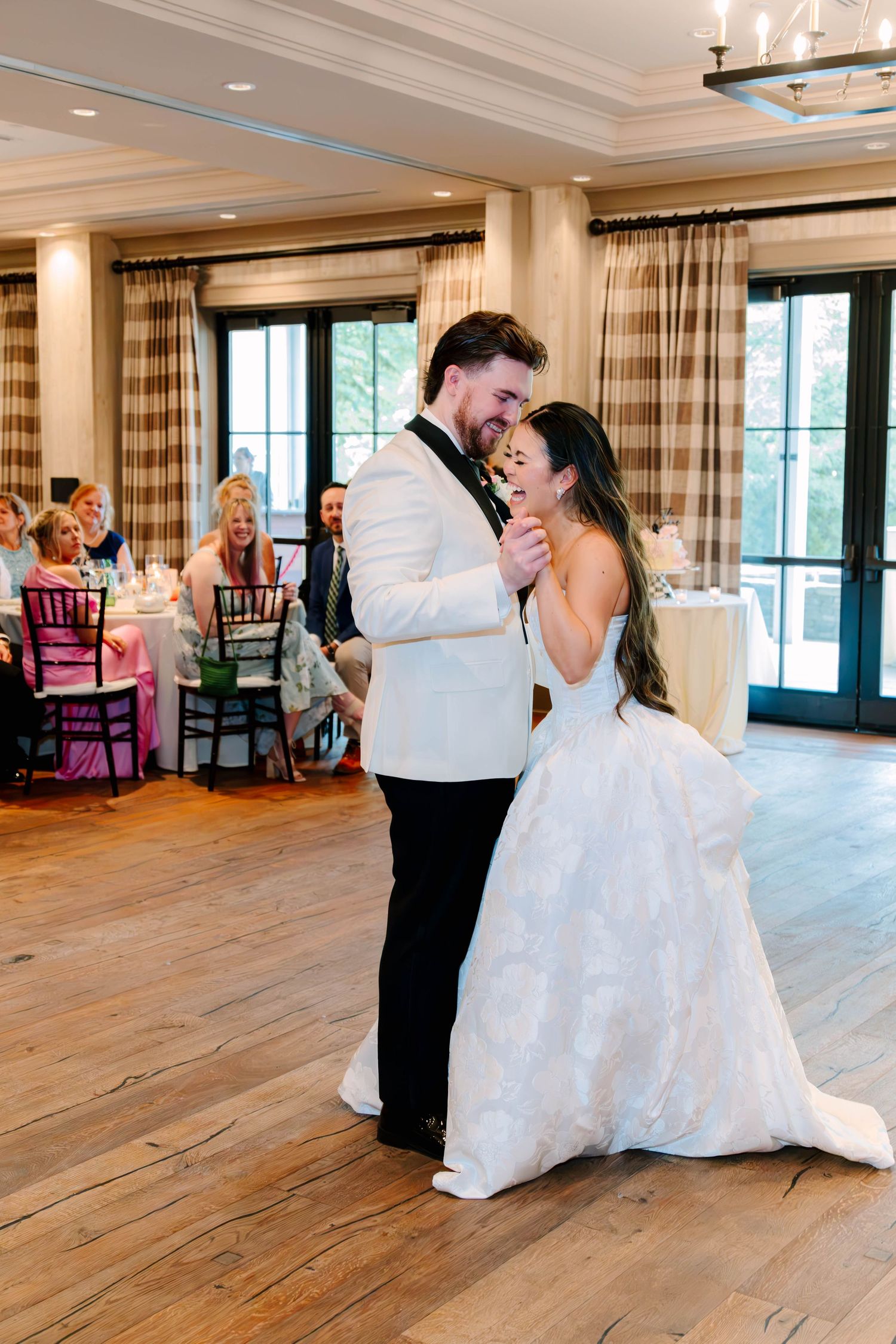 Bride and groom share a tender moment during first dance at elegant wedding reception.