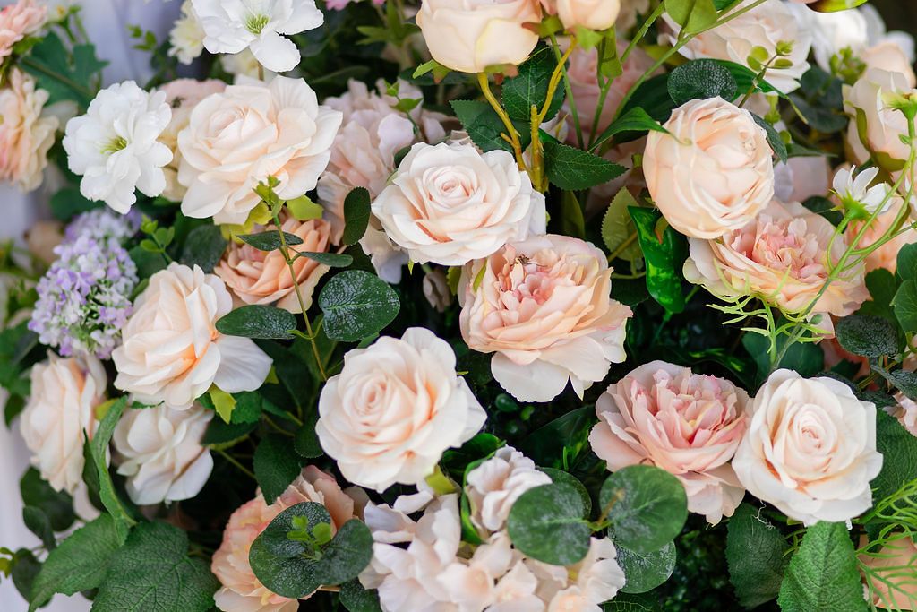 Beautiful arrangement of soft pink and cream roses with green leaves for wedding decor.