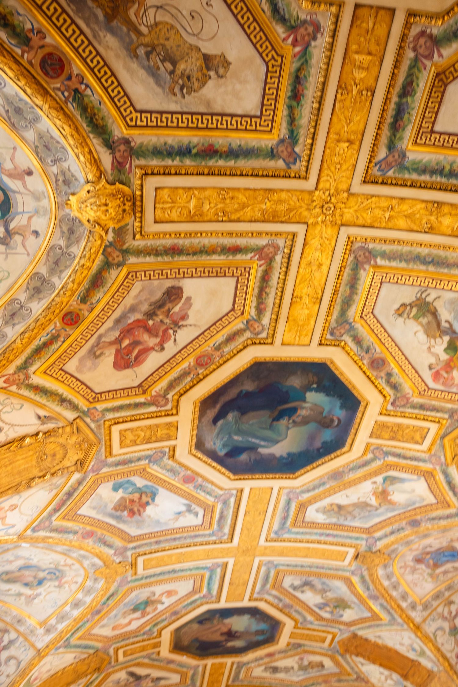 Ornate gilded ceiling with Renaissance-style frescoes and painted medallions in a grand European palace.
