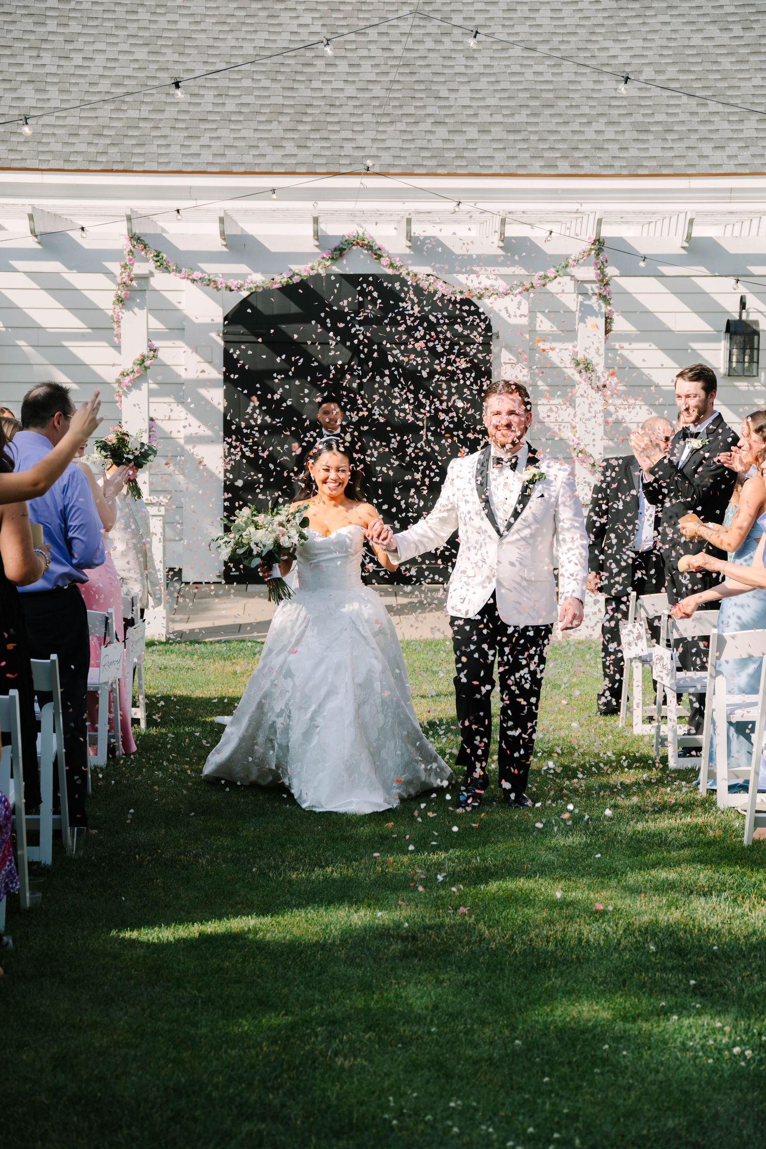 Joyful newlyweds walk down the aisle as guests shower them with colorful confetti.