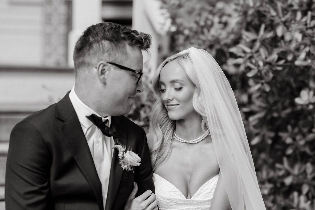 Black and white photo of a bride and groom sharing an intimate moment on their wedding day.