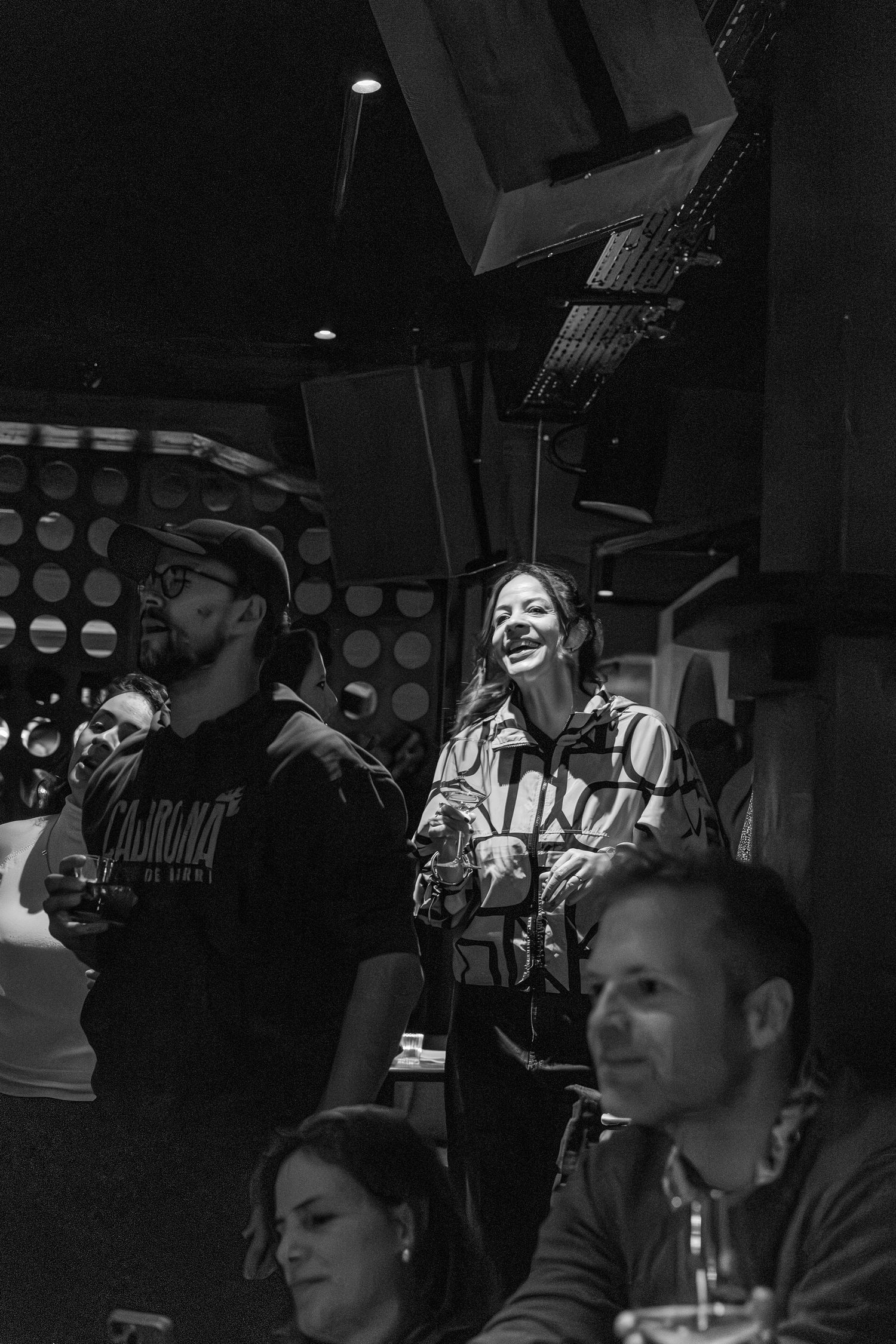 Black and white photo of musicians performing in dimly lit venue.