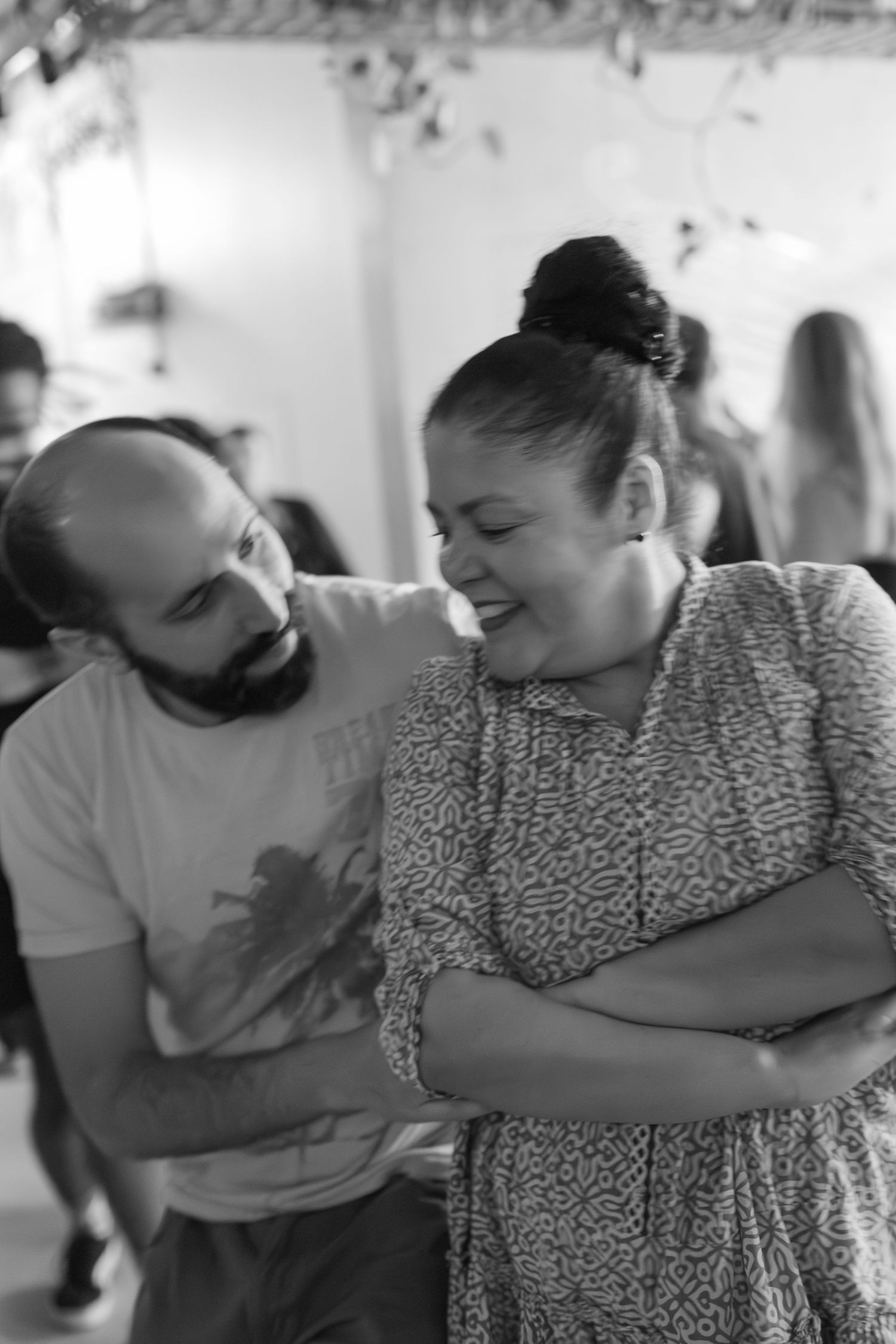 Dancers share a joyful moment while dancing together at an indoor gathering.