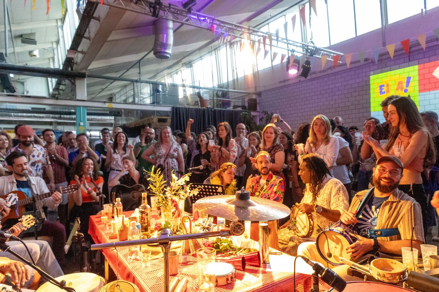 Festive gathering with candle-lit tables and colorful decorations at Samba event.