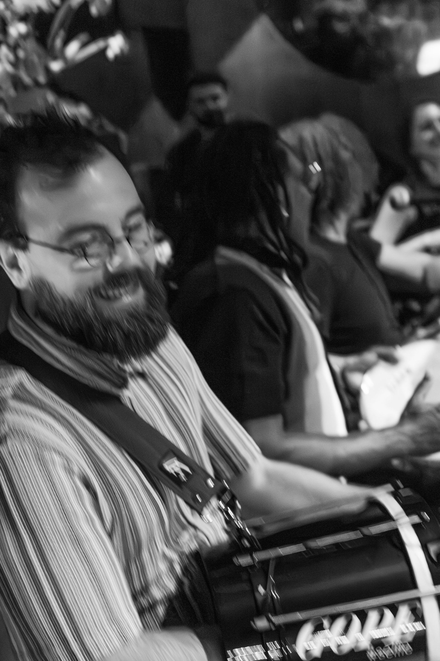 Performer smiling while playing percussion instrument in black and white photo.