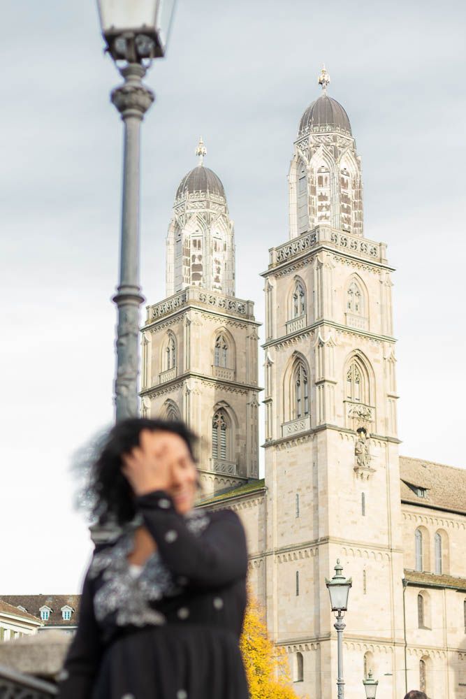 Artistic shot of cathedral towers with streetlamp and person in motion blur.