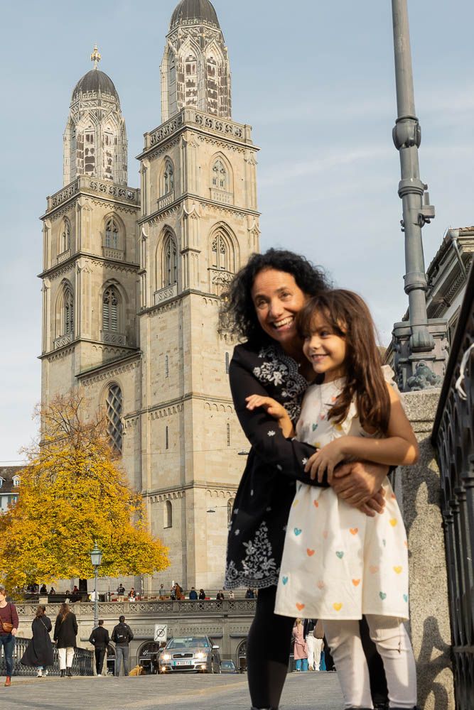 People posing together in front of the iconic Grossmünster cathedral towers in Zurich.