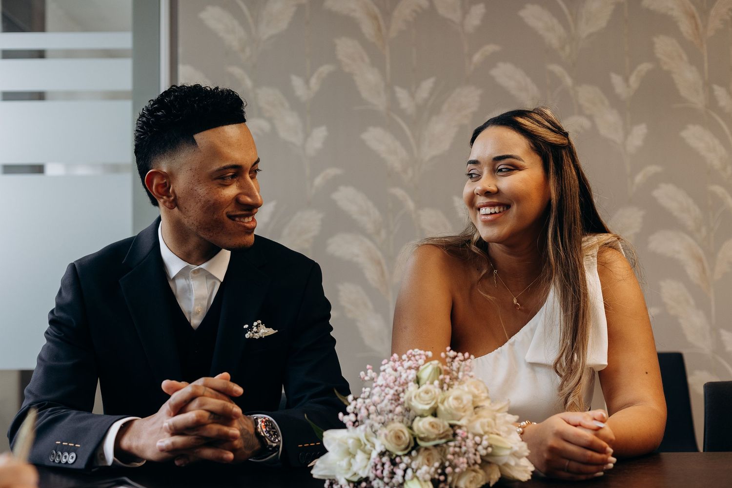 A happy couple shares a joyful moment during their wedding ceremony at a registry office.