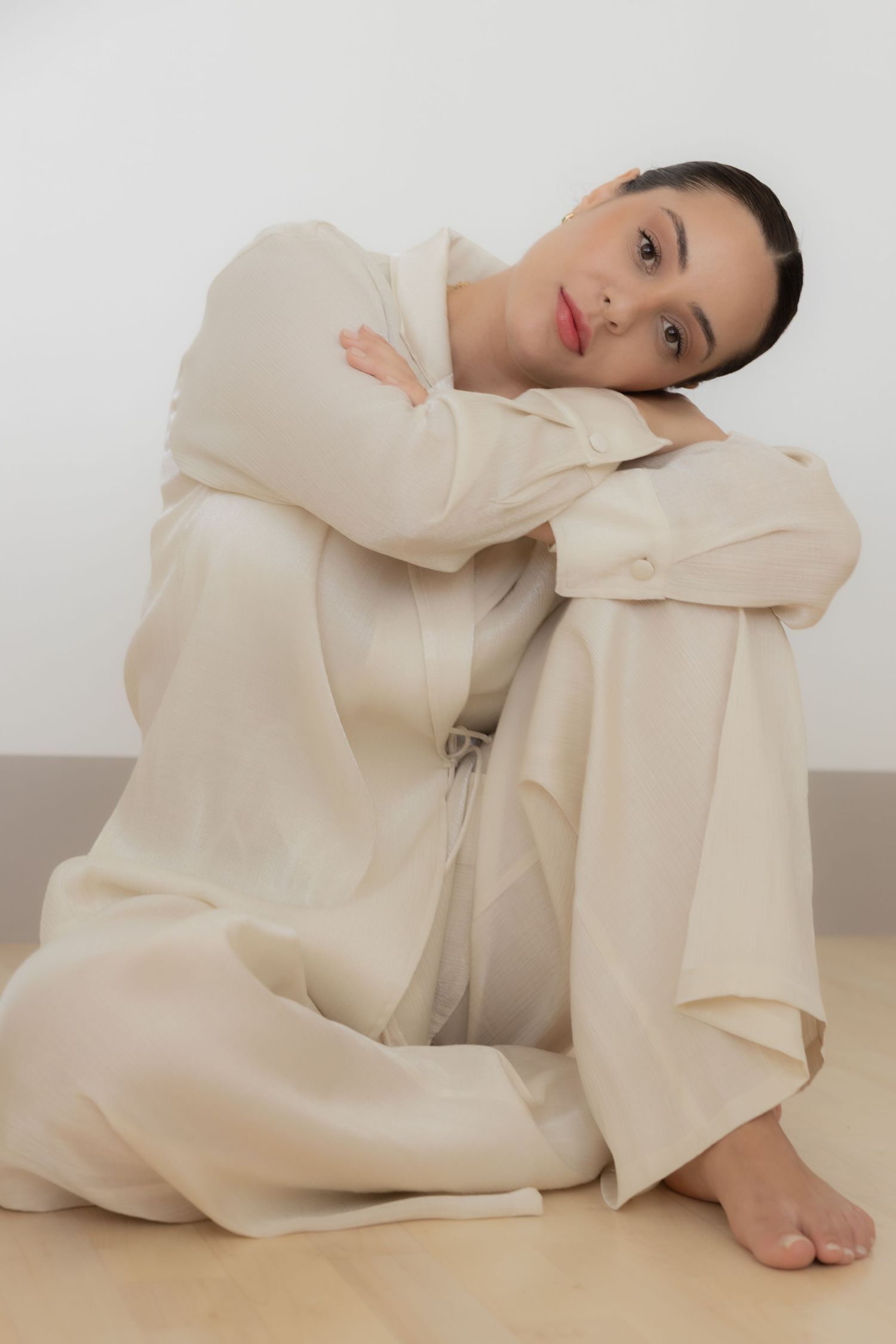 Person in cream-colored loungewear sitting on floor. female portrait photographer in Zürich