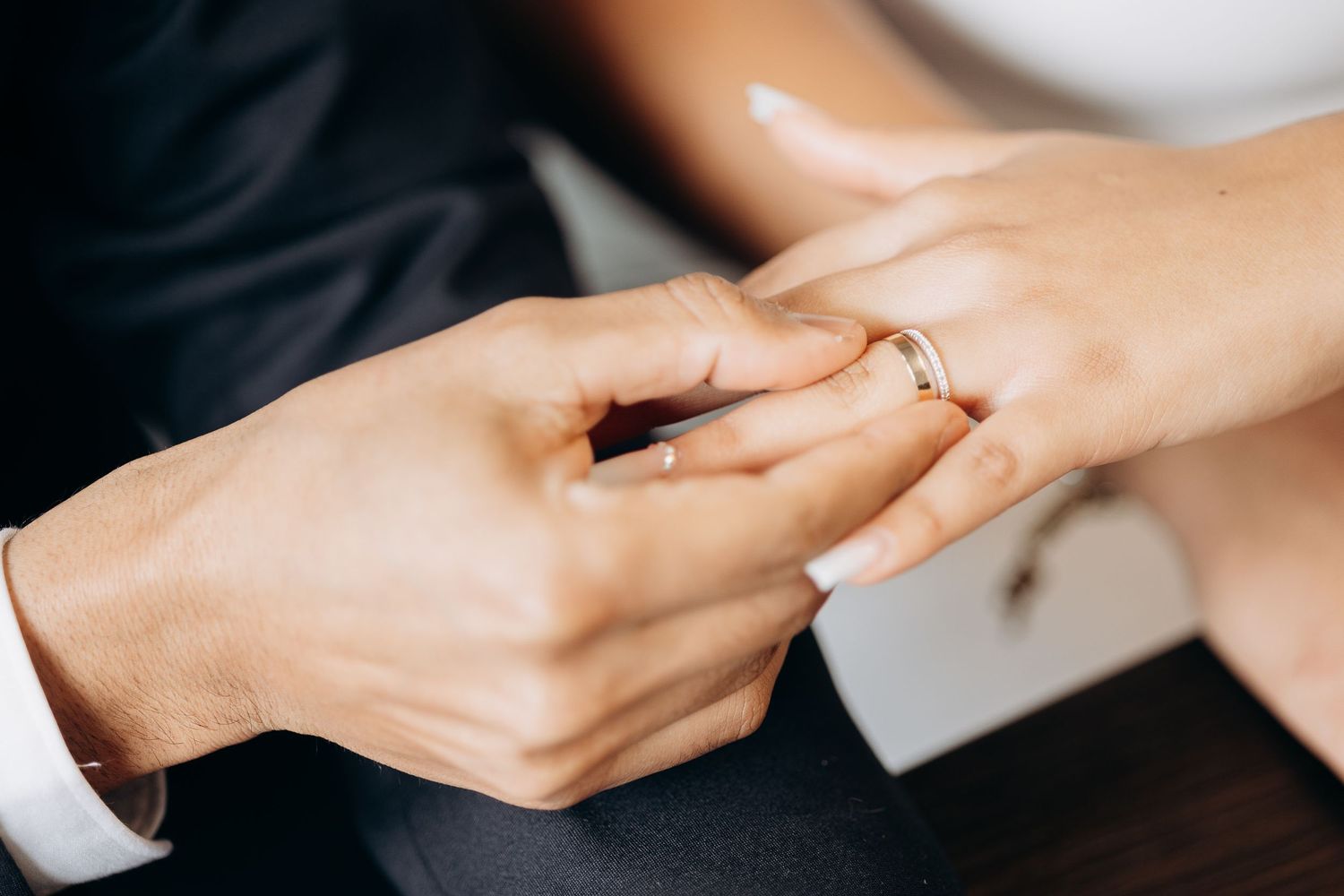 Close-up of exchanging wedding rings during civil ceremony.
