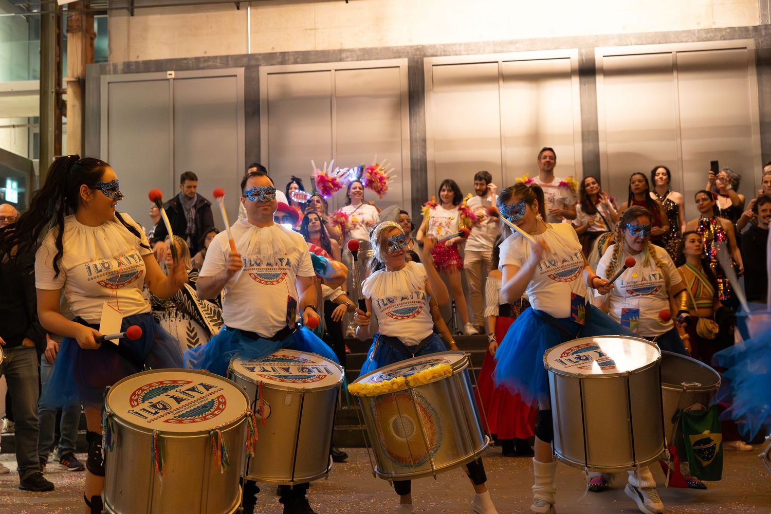 A percussion ensemble performs with drums in a bright indoor venue.