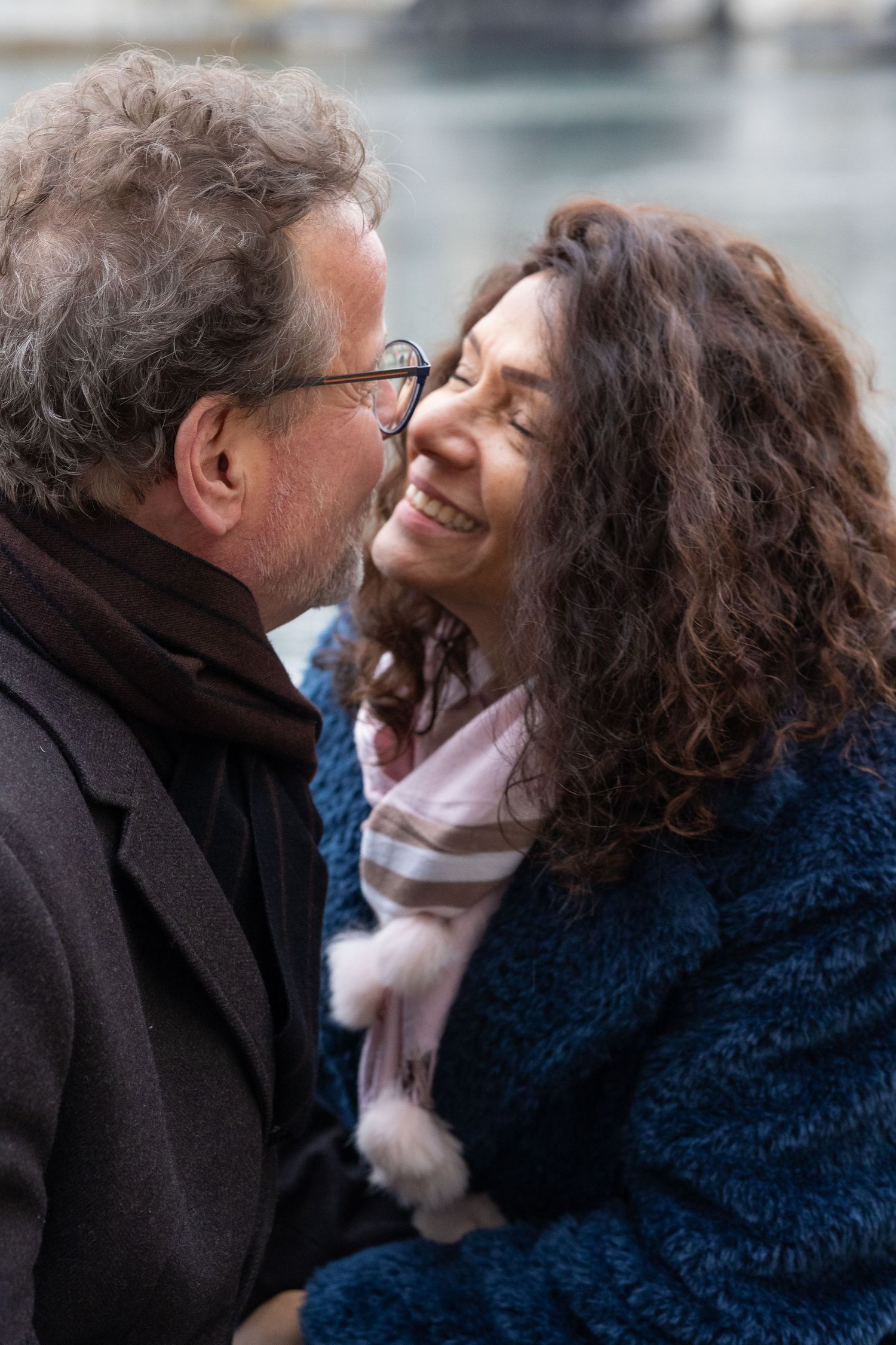 An intimate moment shared between a couple on a romantic winter day in the city.