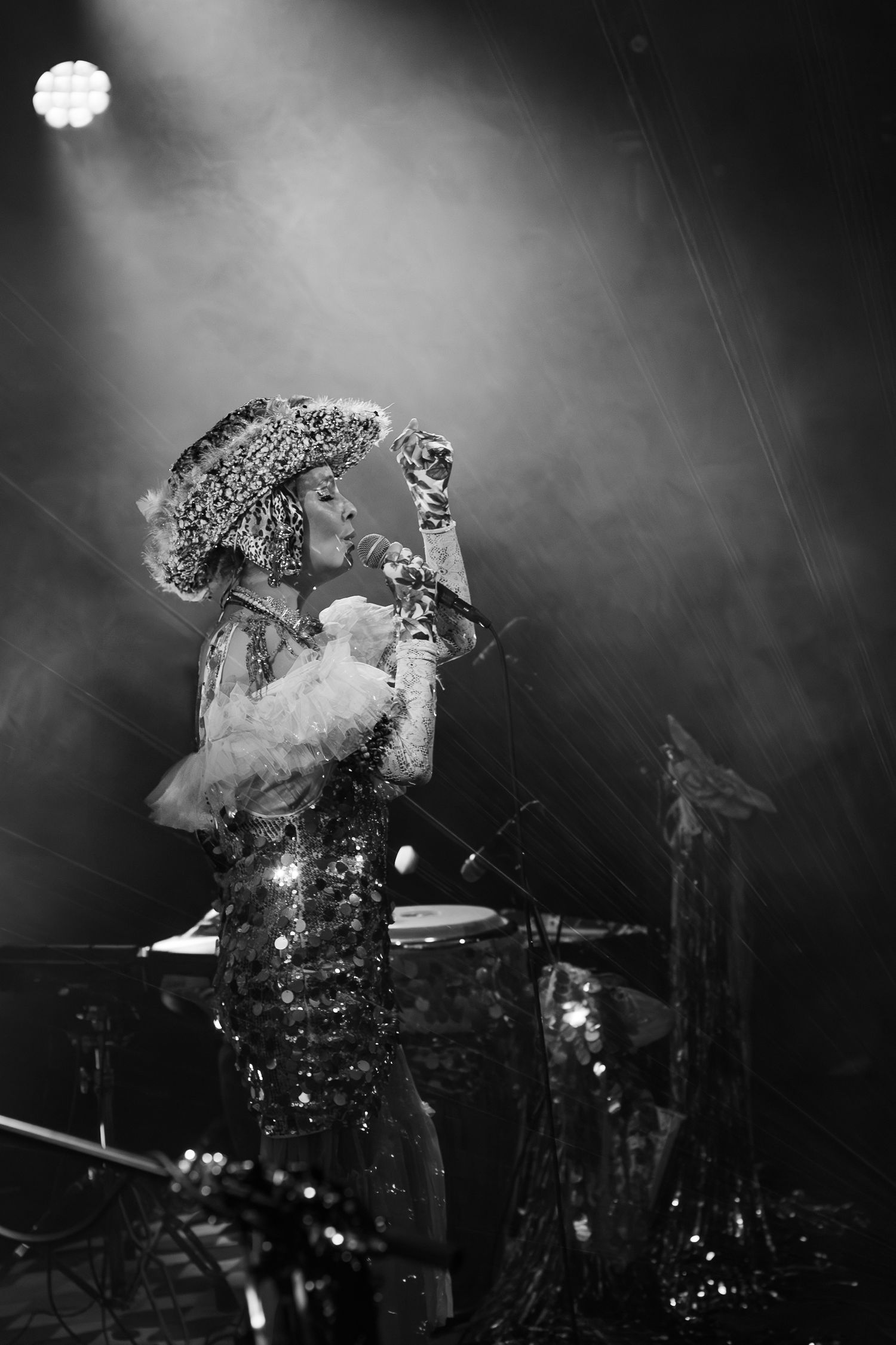 Dramatic stage performance with sparkly costume and theatrical lighting in black and white.
