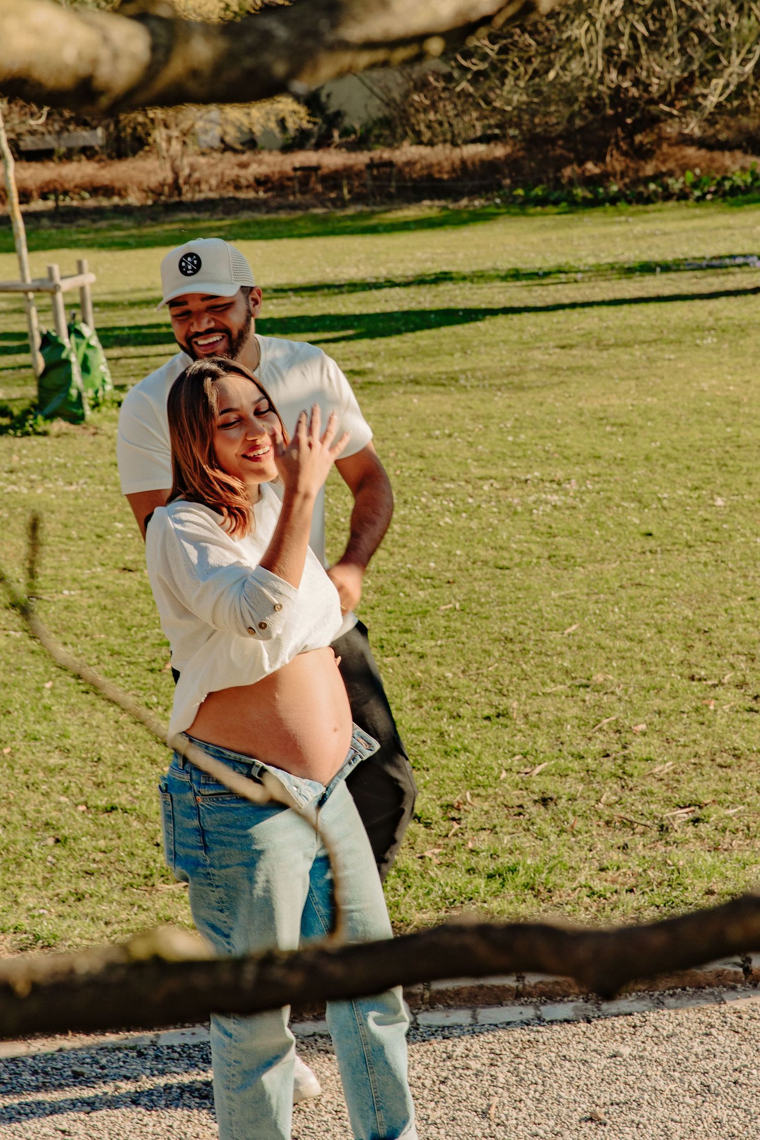 Couple sharing playful moment together in sunny outdoor park setting.