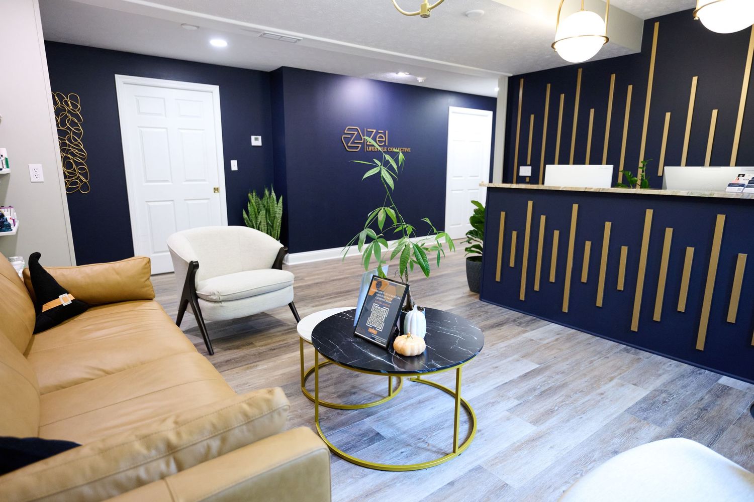 Modern medical office reception area with navy walls, gold accents, and contemporary furniture.