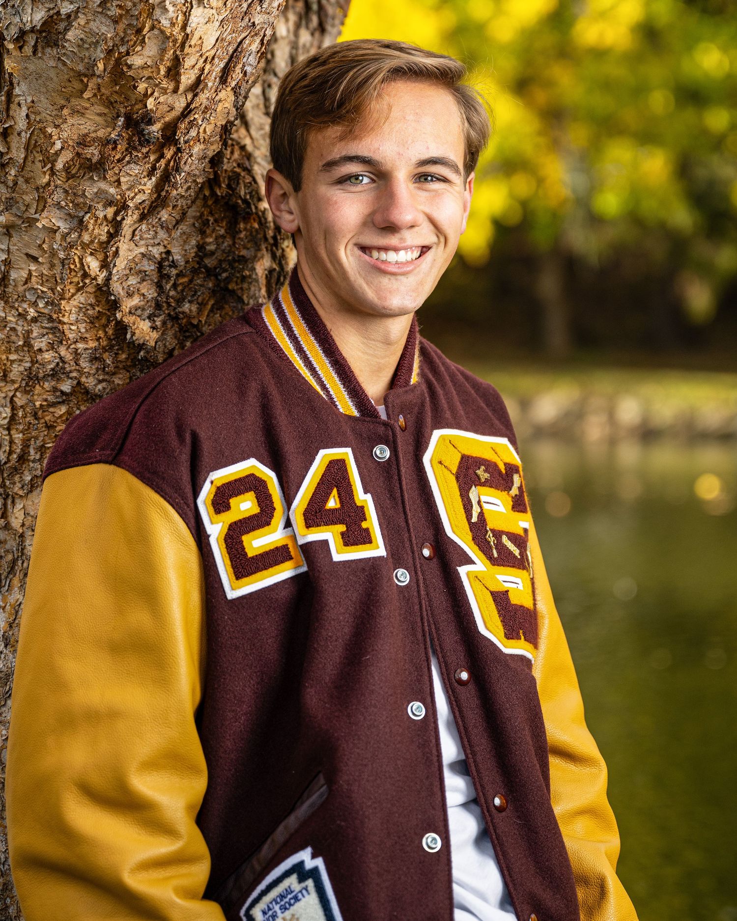 Letterman varsity jacket with burgundy and gold colors shown in a series of outdoor photos.