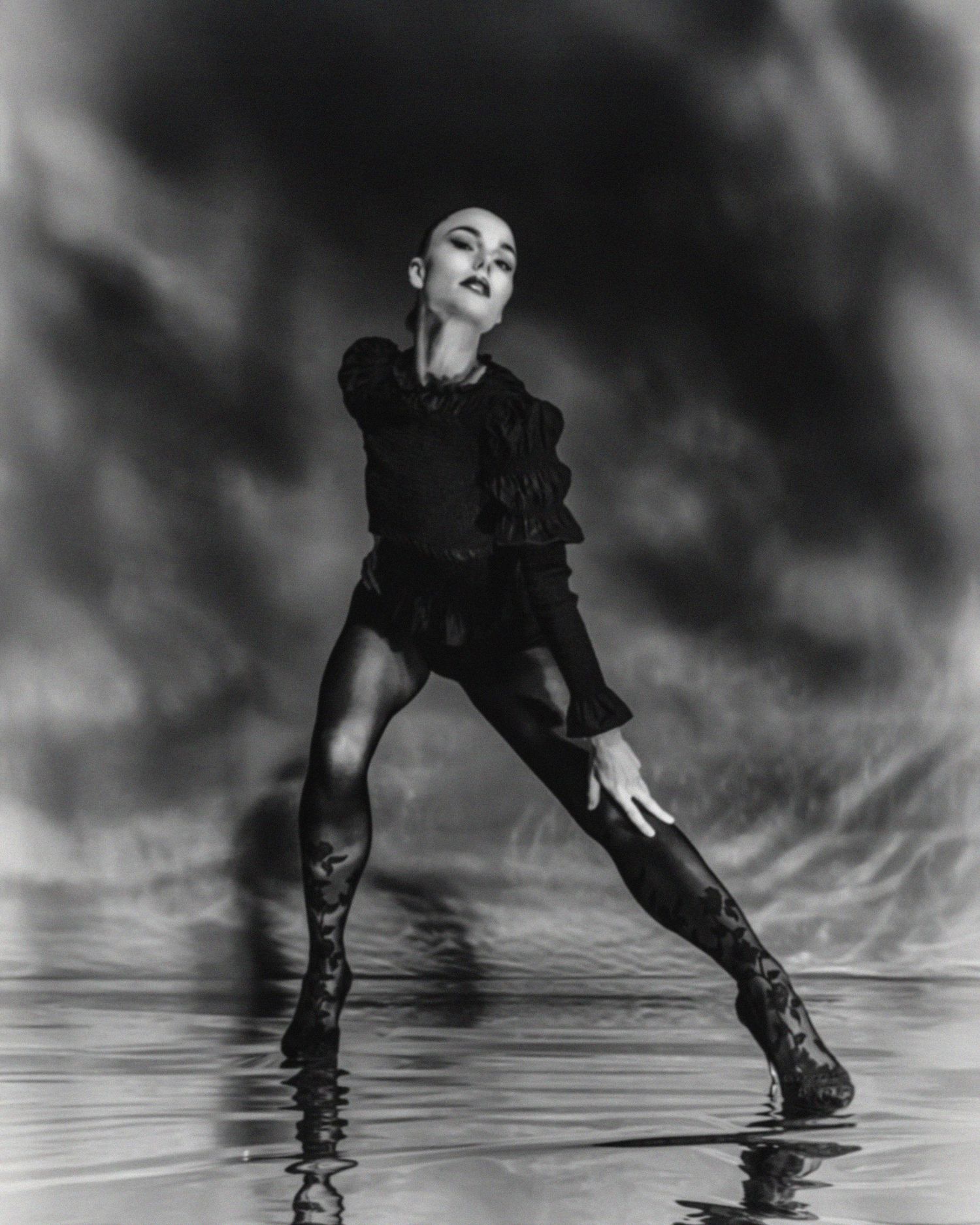 Black and white artistic photos showing dramatic poses with reflective surface effects.
