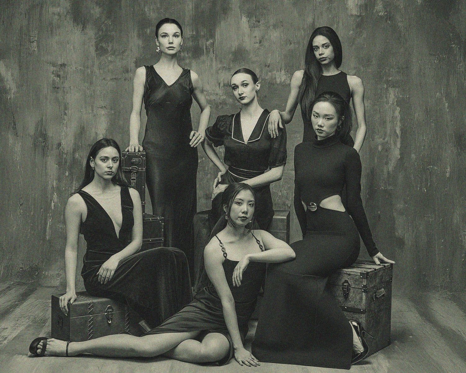 Artistic black and white portrait of group in dark elegant attire.
