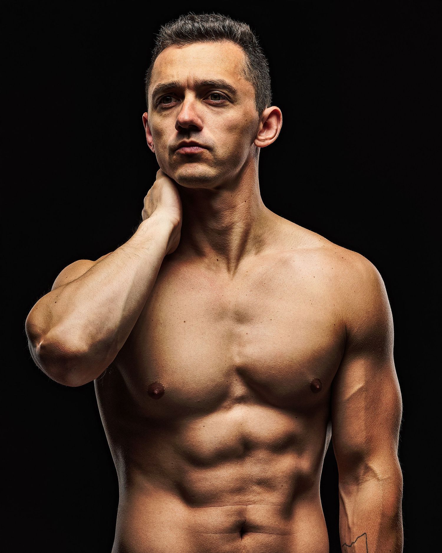 Dramatic black and white portraits of muscular torso against dark background.