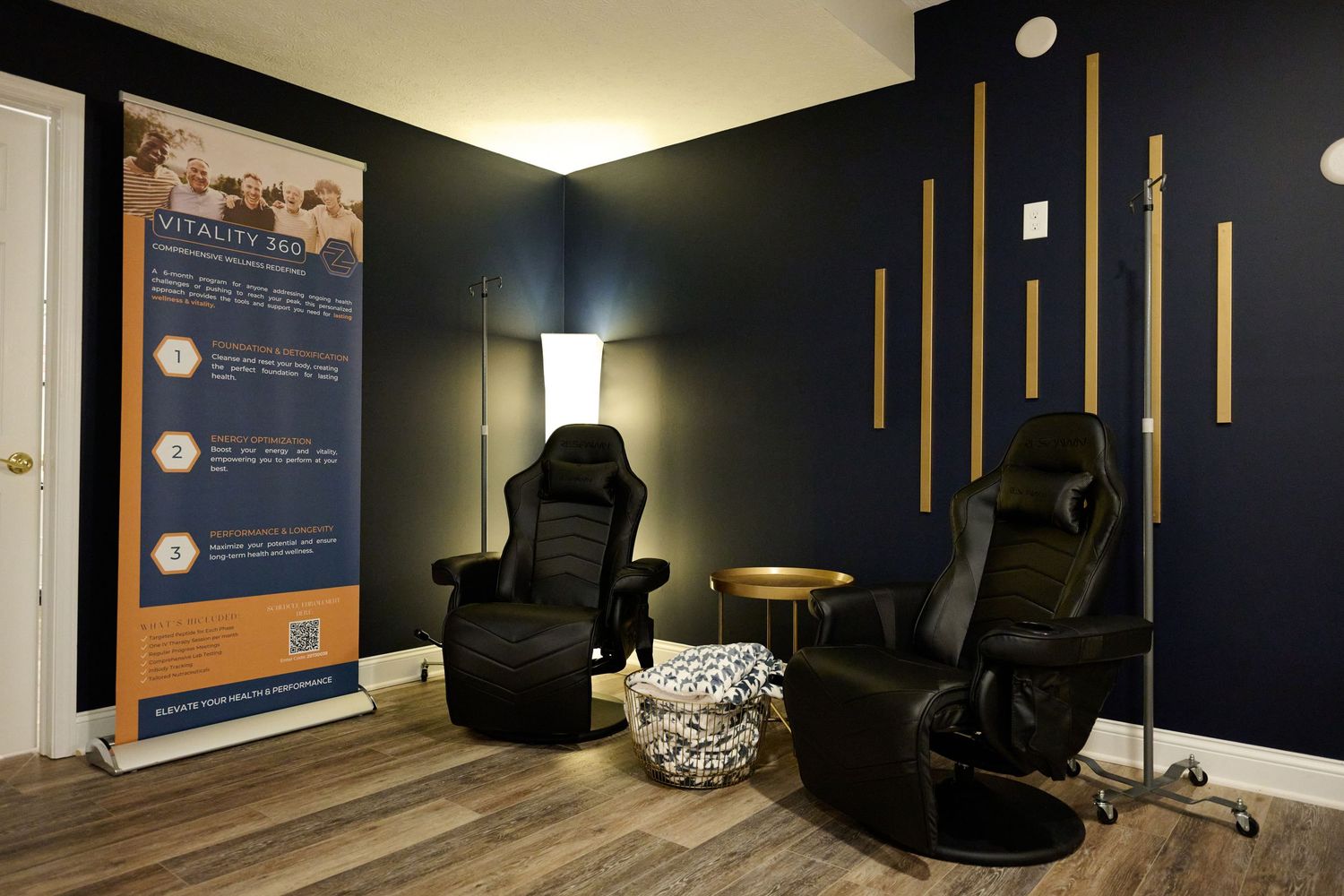 Relaxation area with dark walls featuring gaming chairs and wooden accent details.