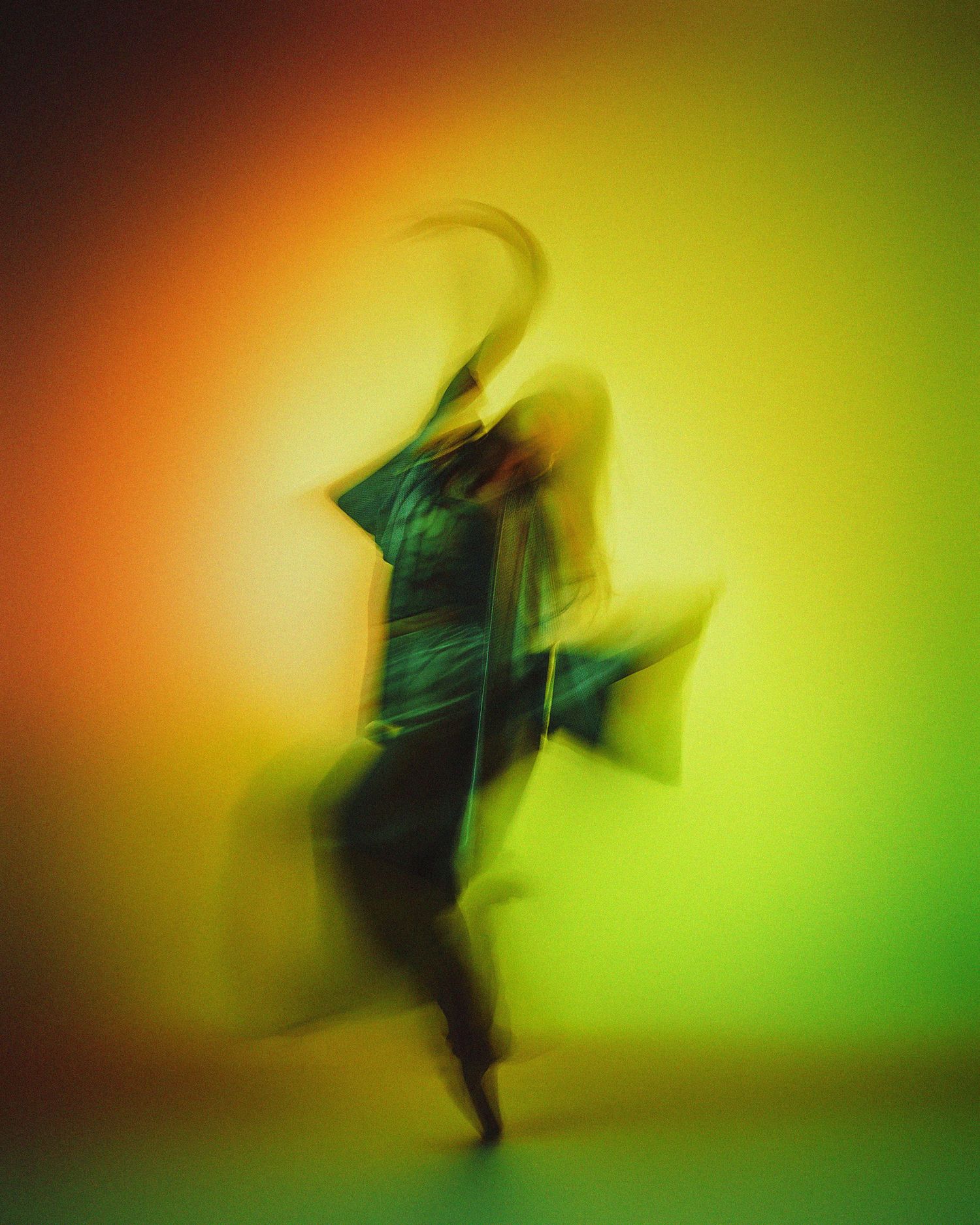 Abstract motion blur dance photography against colorful yellow and green backdrop.
