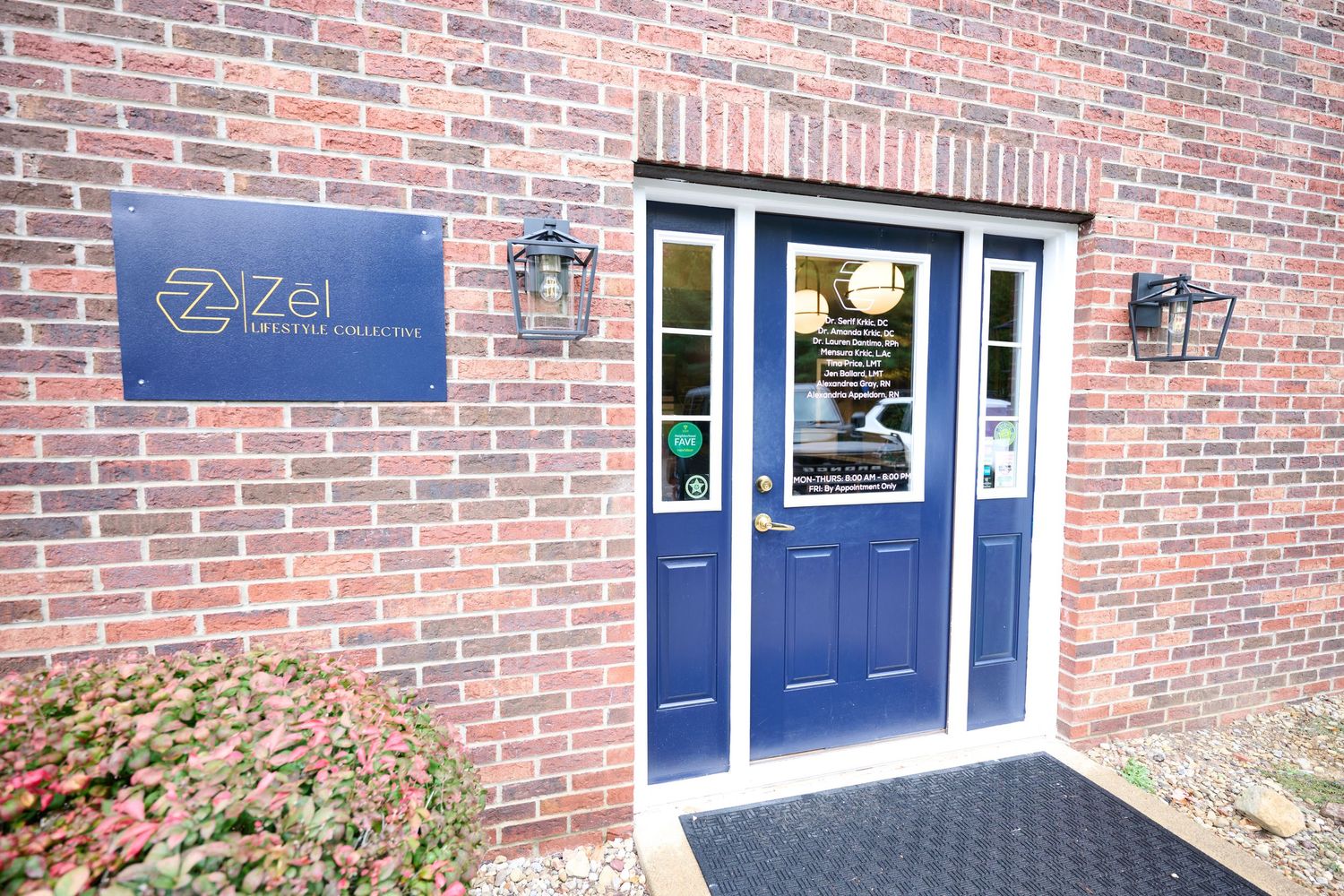 Exterior view of medical office entrance with blue door and brick facade featuring company signage.