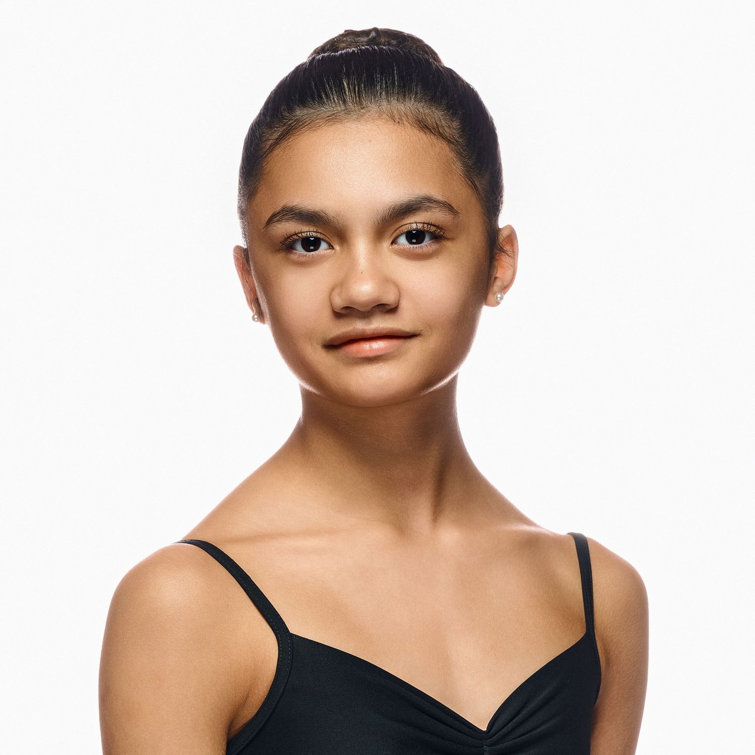 Portrait of a ballet dancer in black leotard against white background.