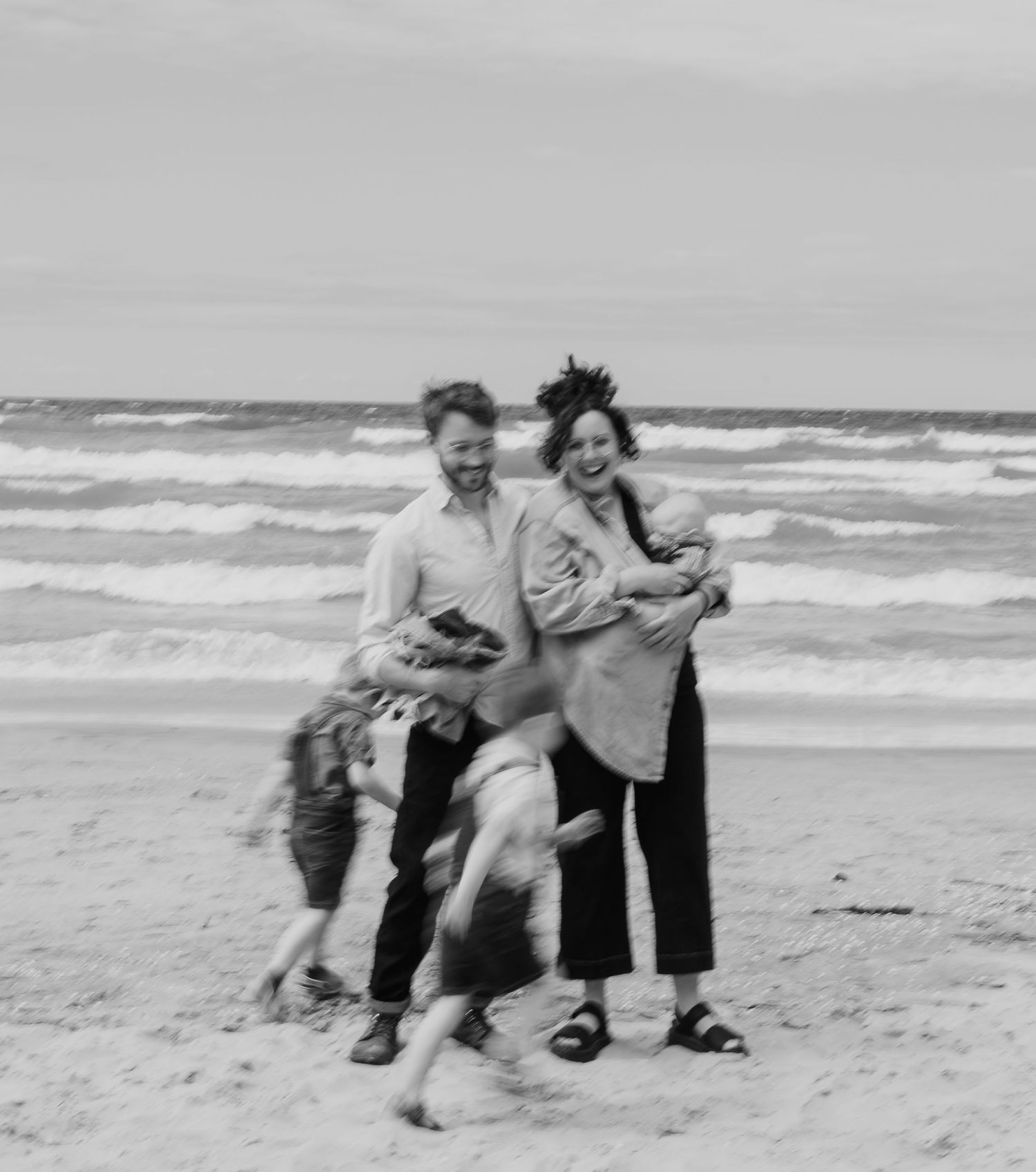 Vintage black and white photo sequence showing playful interactions between people at a beach with rolling waves.