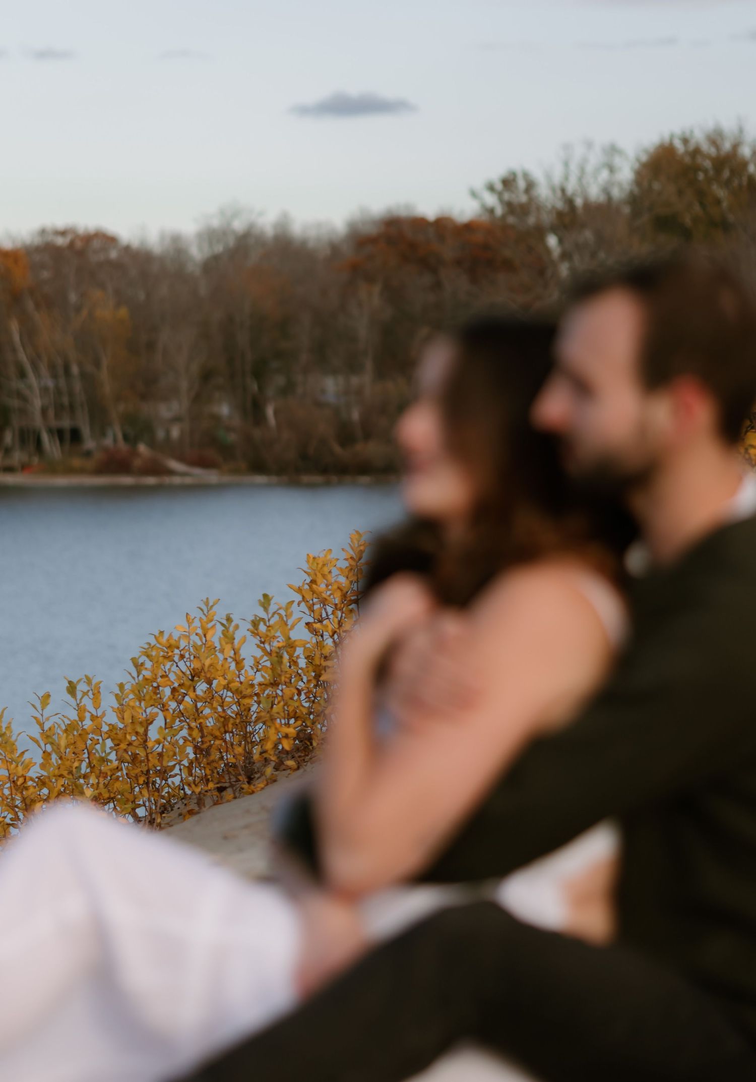 A blurred artistic shot of people silhouetted against an autumn lake landscape in Prince Edward County