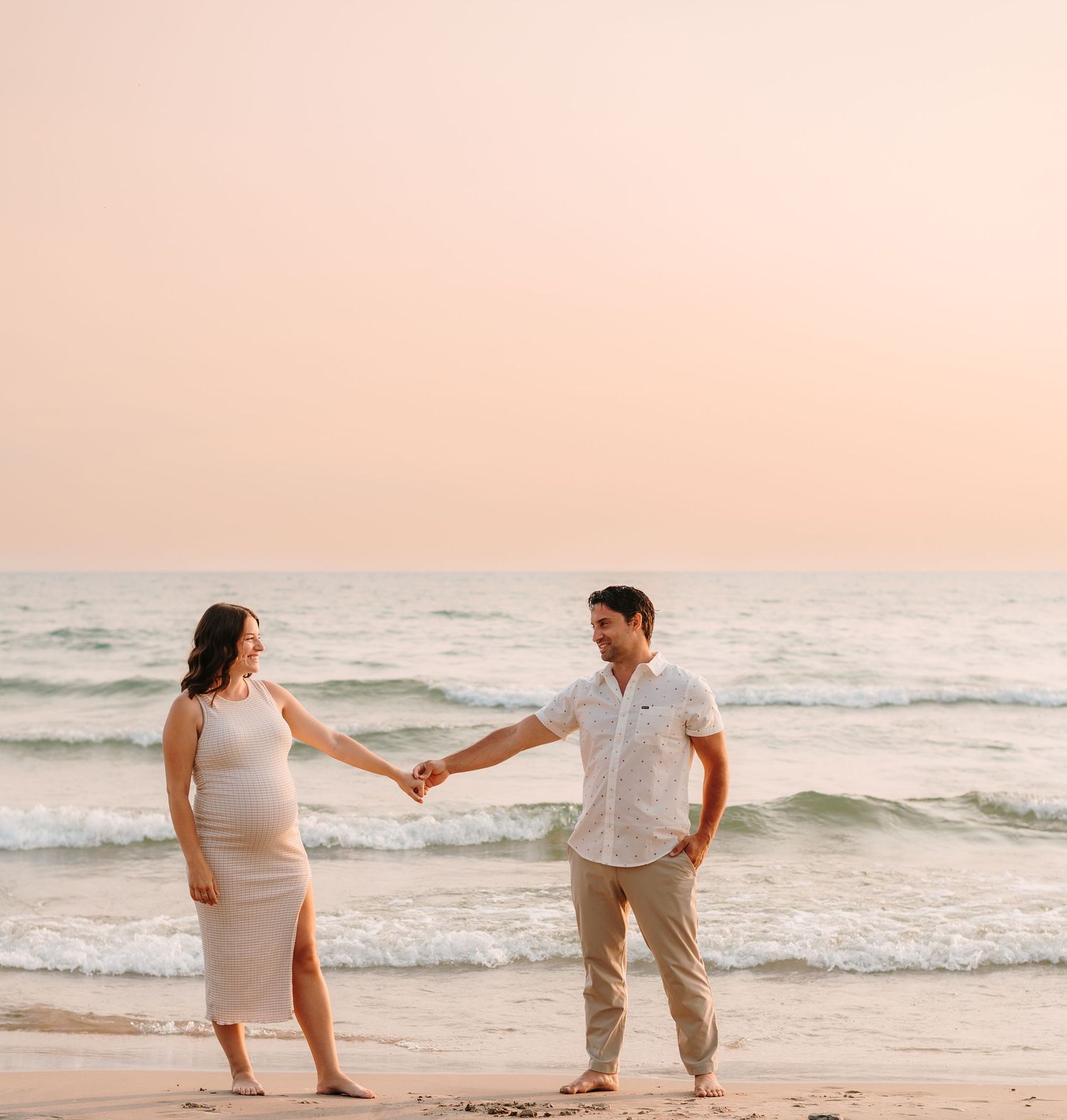 Romantic beach engagement photo sequence at sunset with couple in light summer attire.