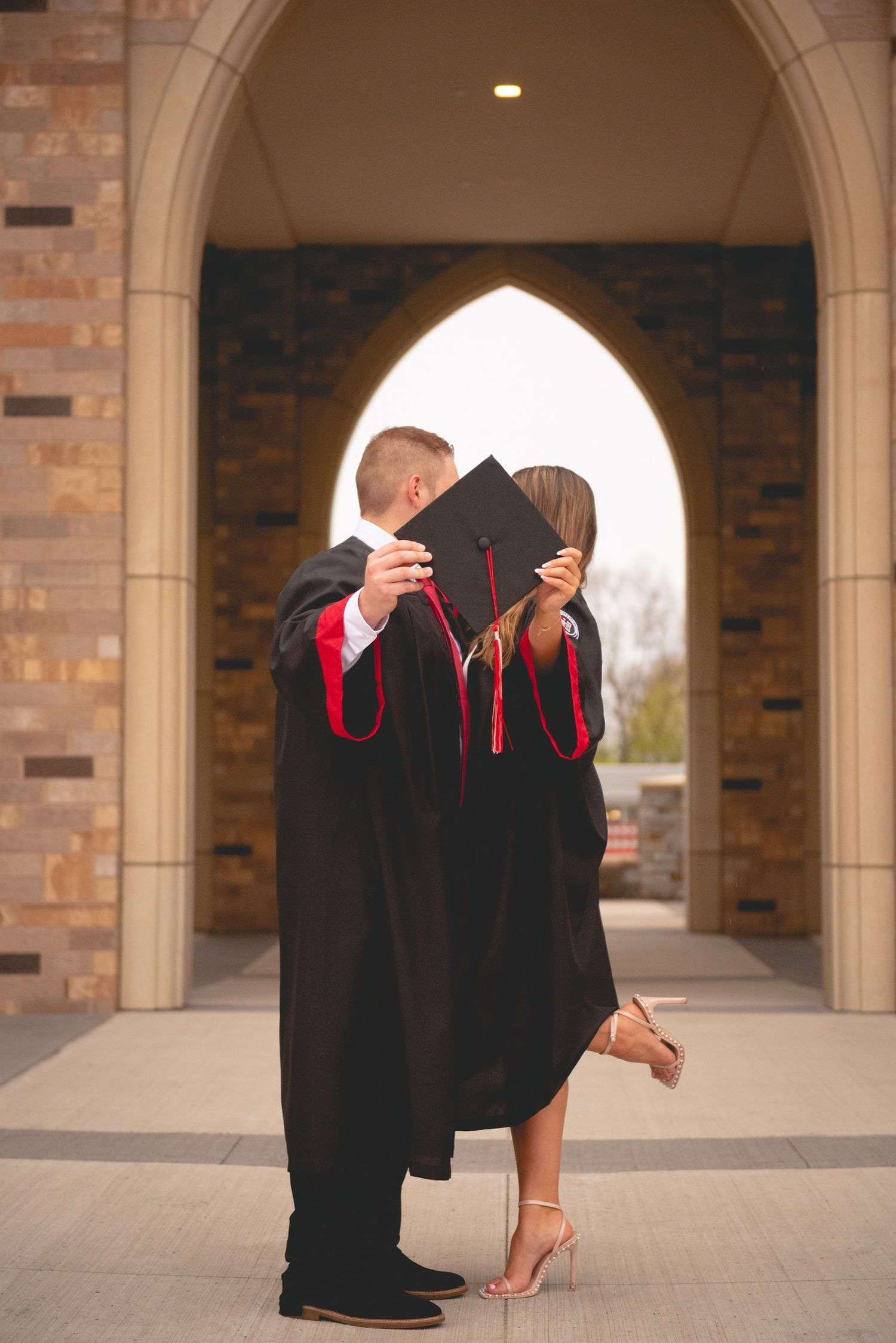 A sequence showing graduation caps being tossed in front of an arched brick building.