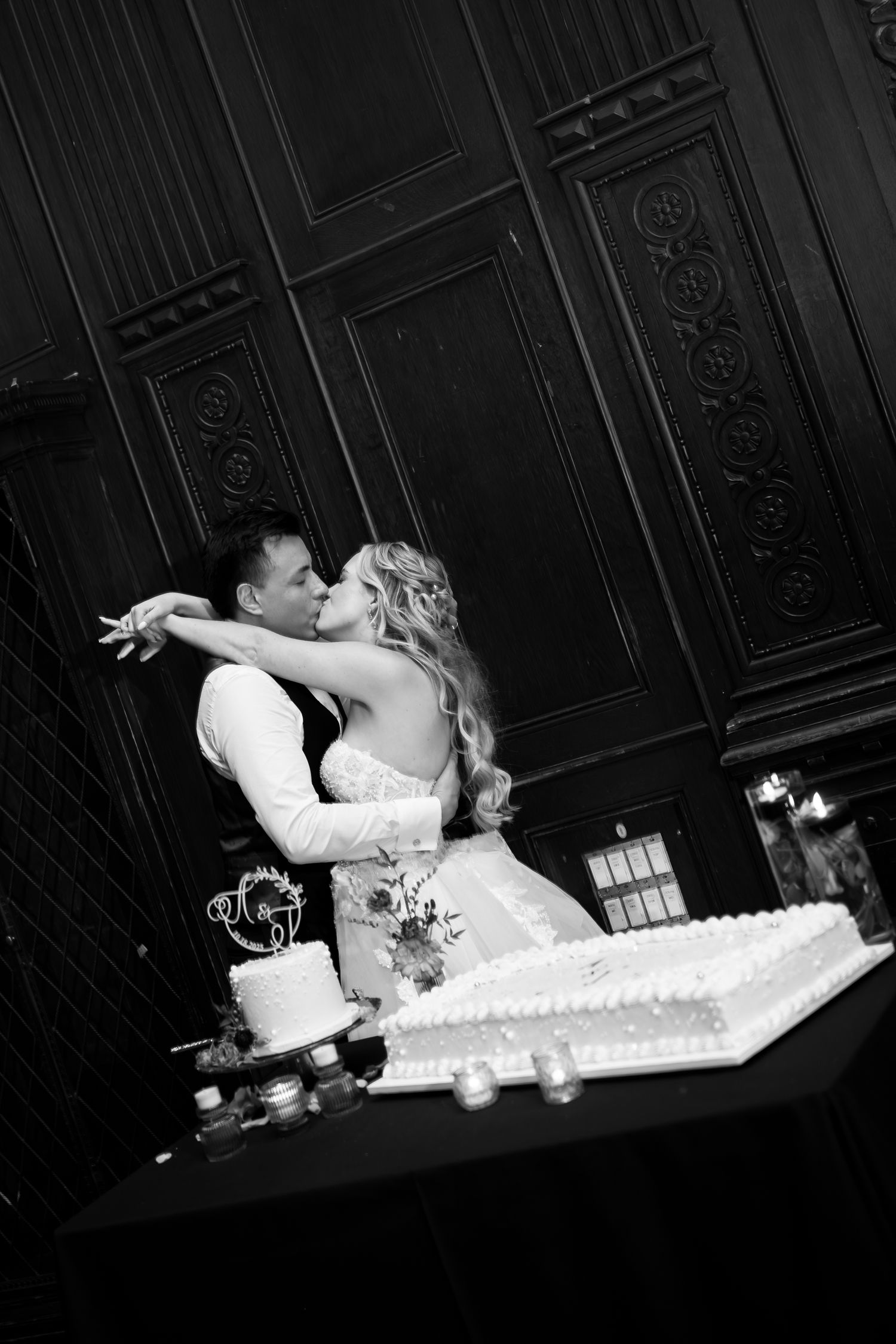 Black and white wedding cake cutting sequence captured in dramatic lighting.