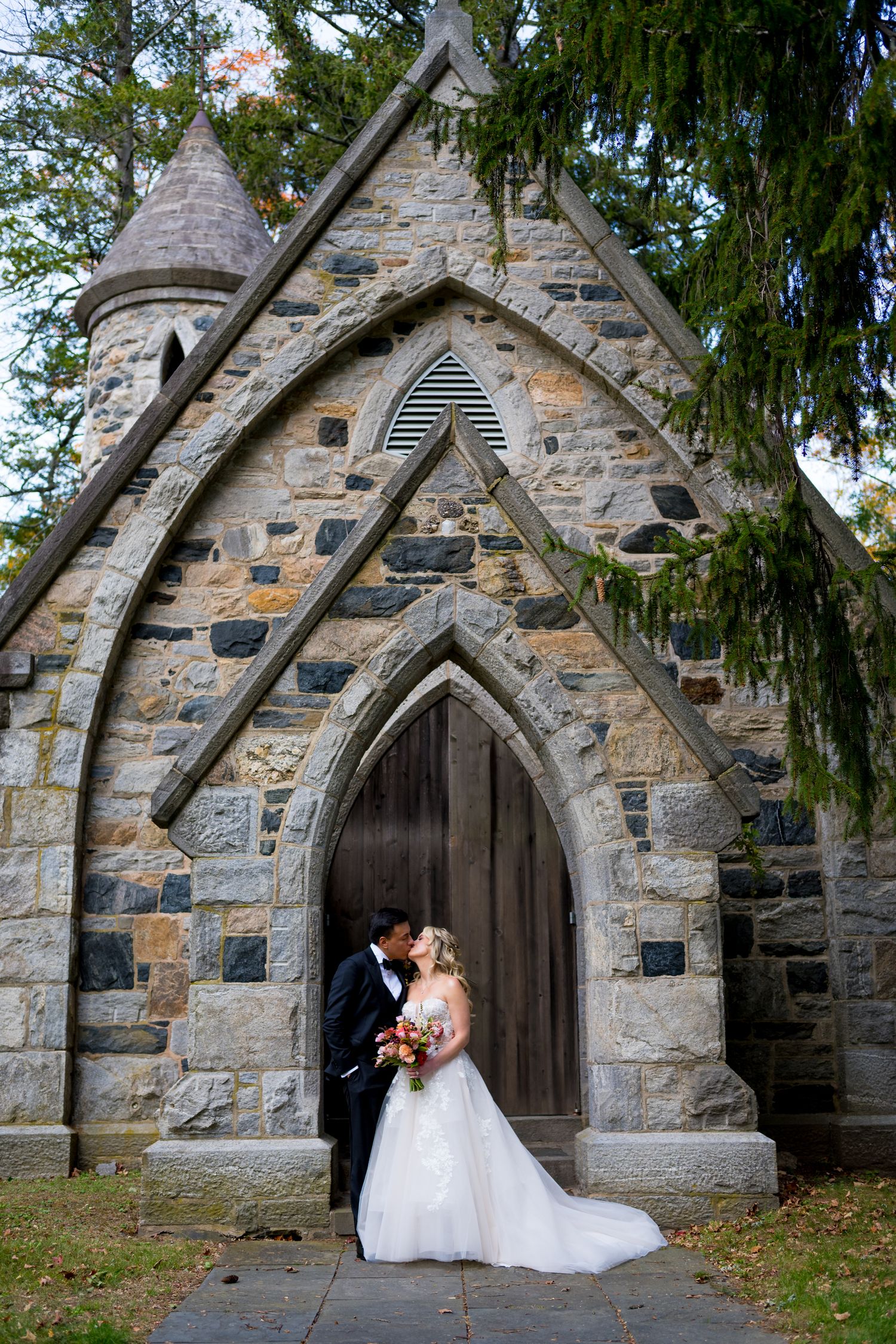 A romantic wedding photoshoot at a stone church entrance with arched doorways at Reid Castle in New York.