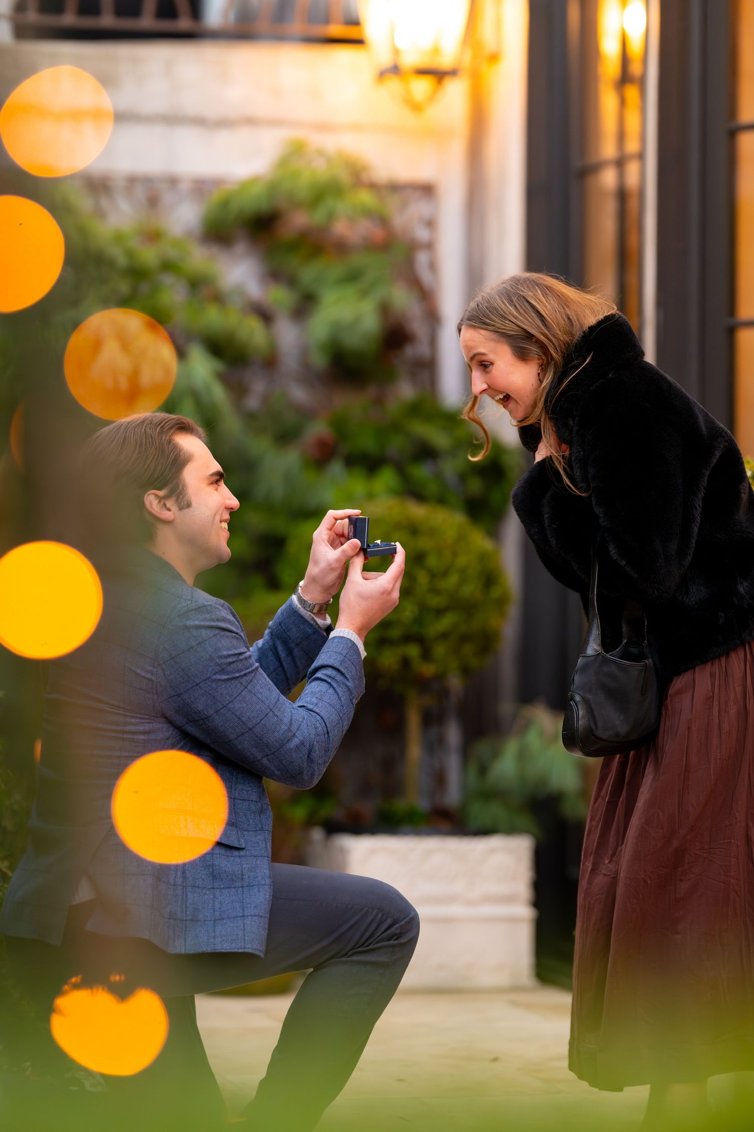 Romantic proposal moment illuminated by warm glowing lights in an outdoor setting in Greenwich, Connecticut.