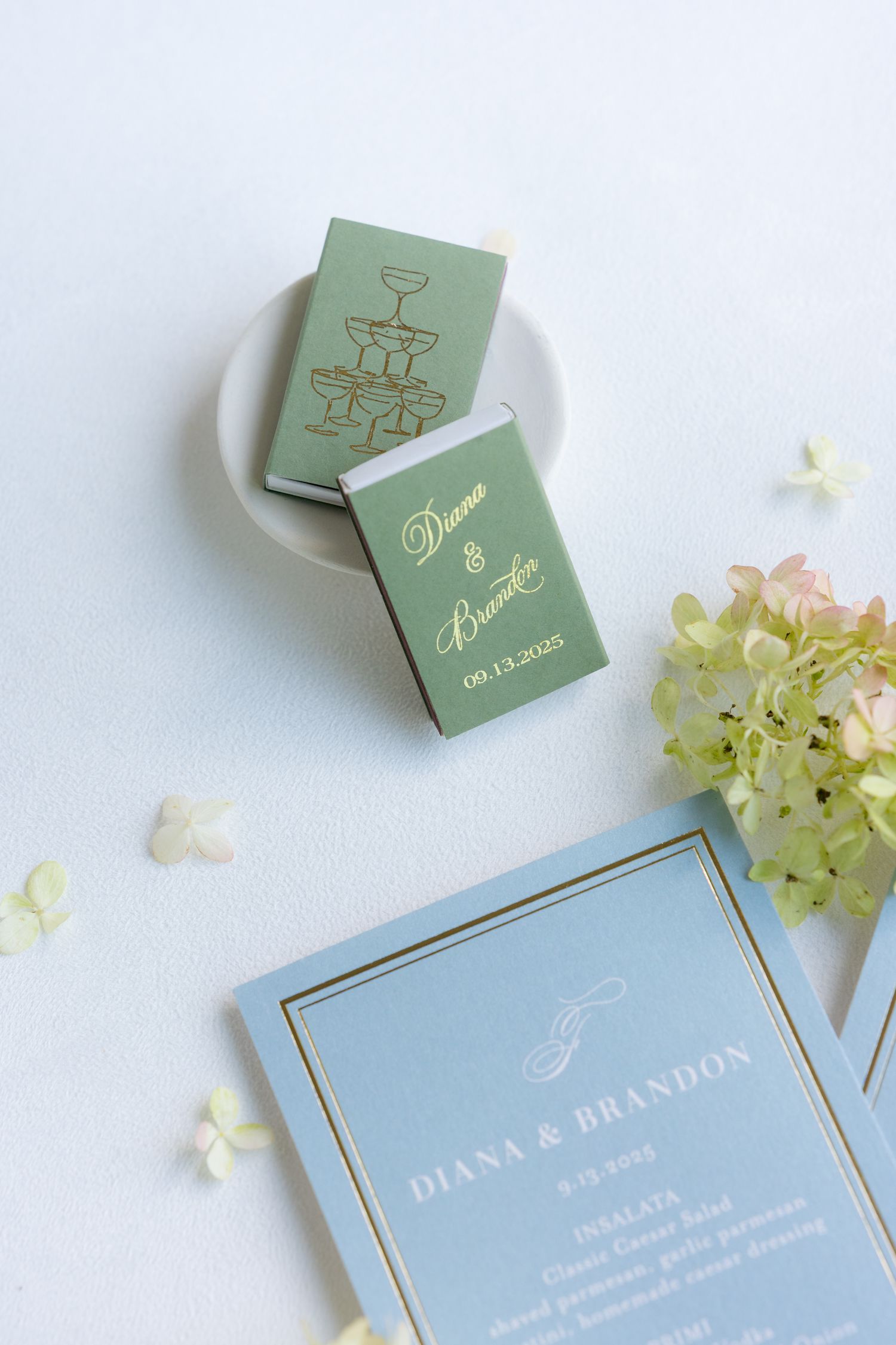 Wedding stationery featuring mint green and blue invitation cards with floral details.