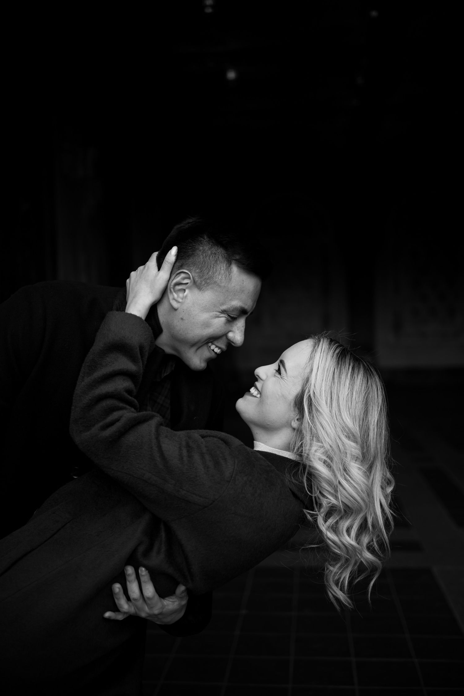 Candid black and white portrait capturing a joyful romantic embrace in Central Park in Manhattan, New York.