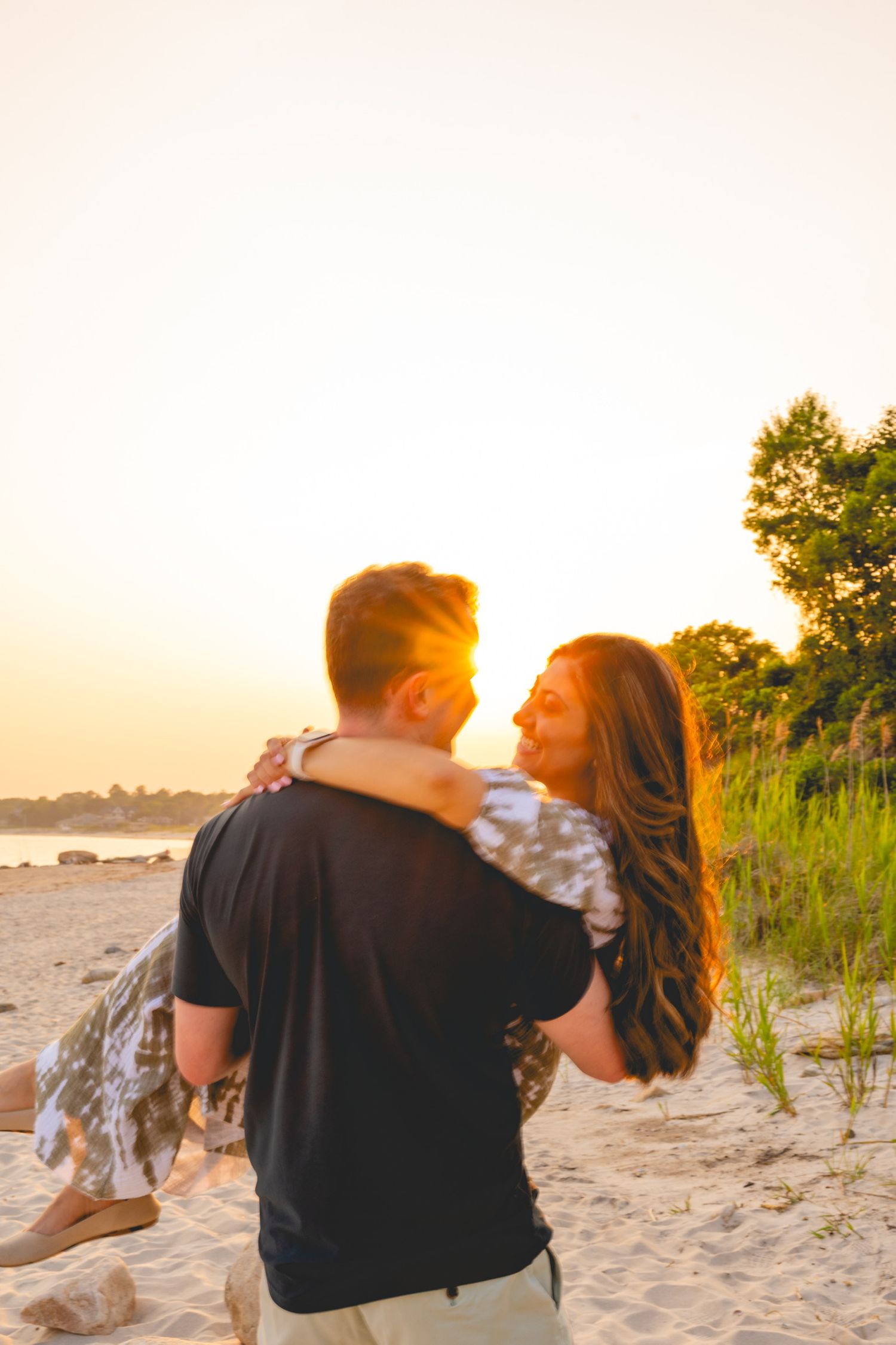 Romantic sunset moment on sandy beach with golden light filtering through trees at Harness Memorial State Park.