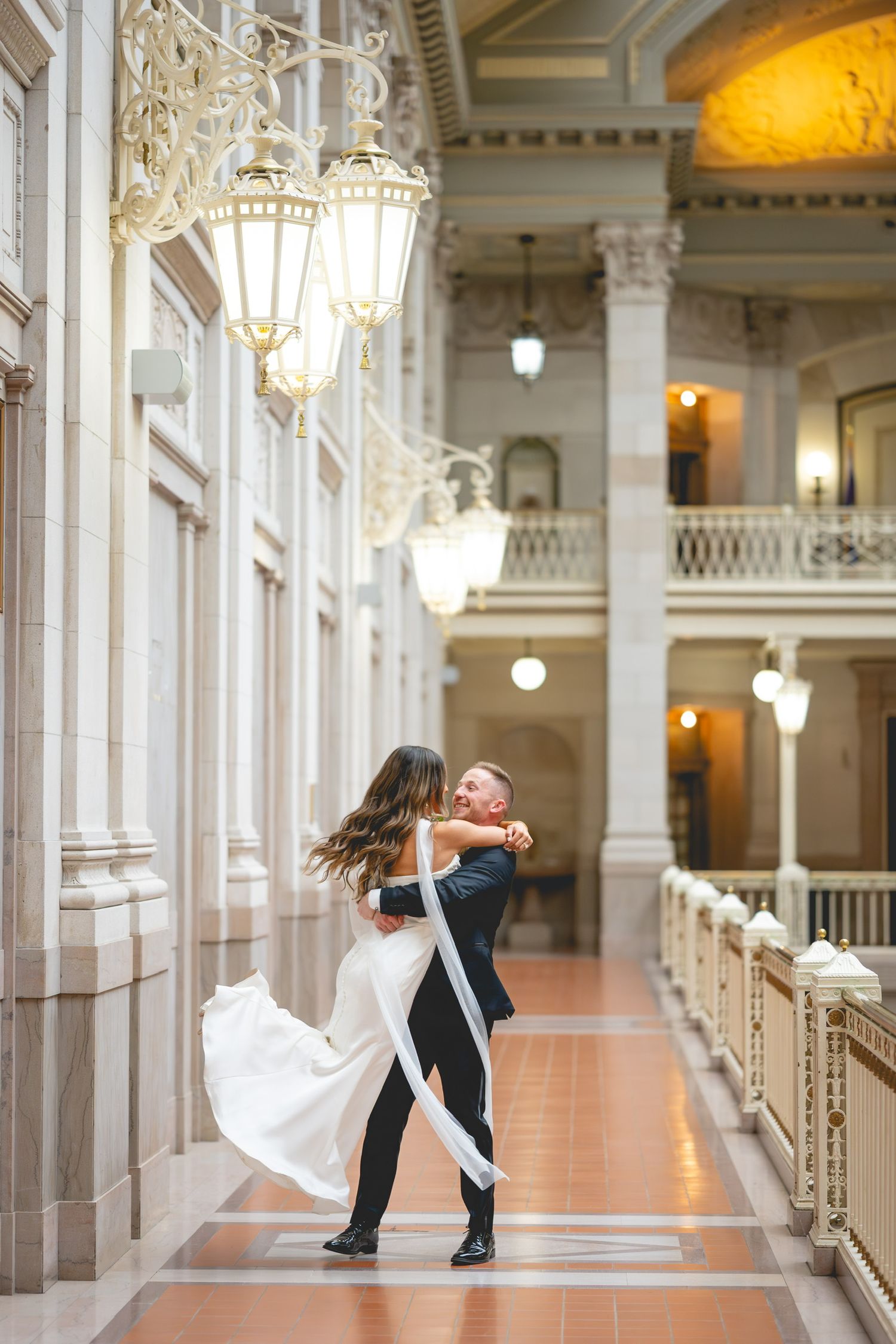 Wedding couple performs dramatic dip poses in grand hallway with elegant architecture at Hartford City Hall in Connecticut.