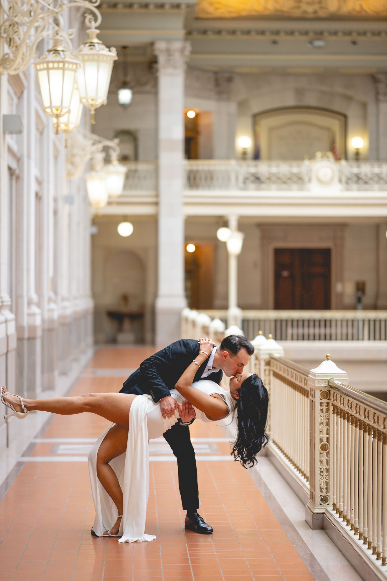 A couple performs dramatic dance poses in an elegant hallway with classical architecture at Hartford City Hall.