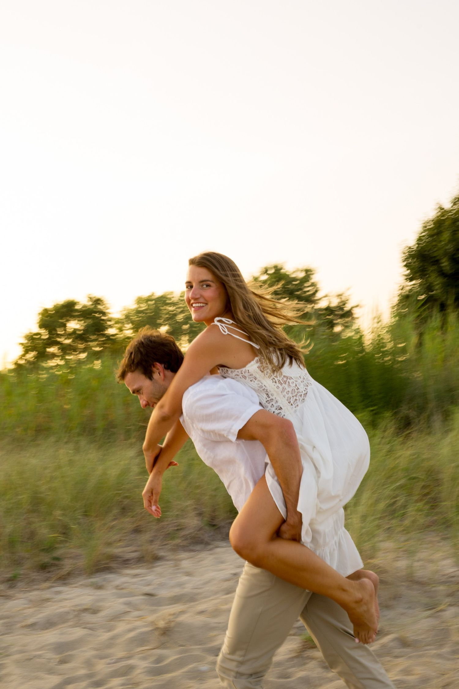 A playful couple spins and dances on the beach at sunset in Westport, Connecticut.