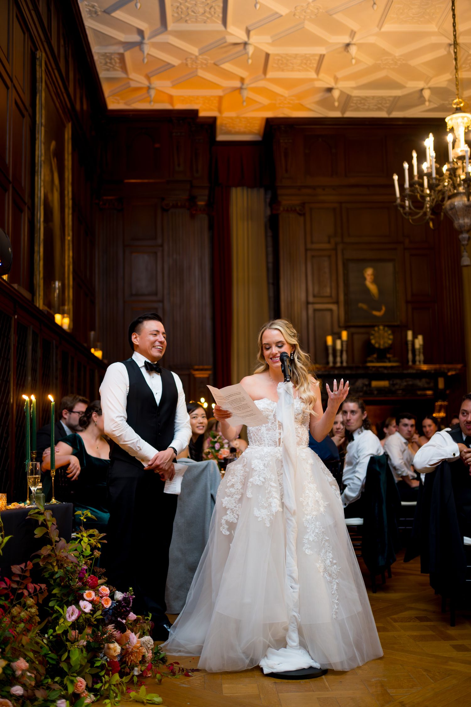 Wedding guests dance and celebrate on the ornate ballroom floor during an elegant evening reception.