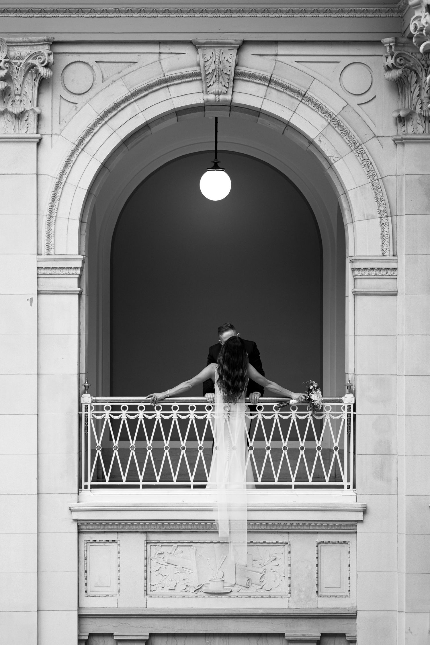 Artistic black and white architectural photograph of arched balconies with dramatic lighting.