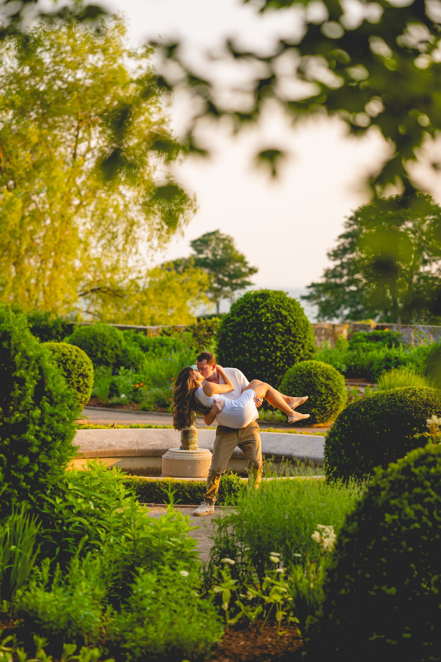 Garden photoshoot sequence showing couple in romantic poses among manicured hedges.