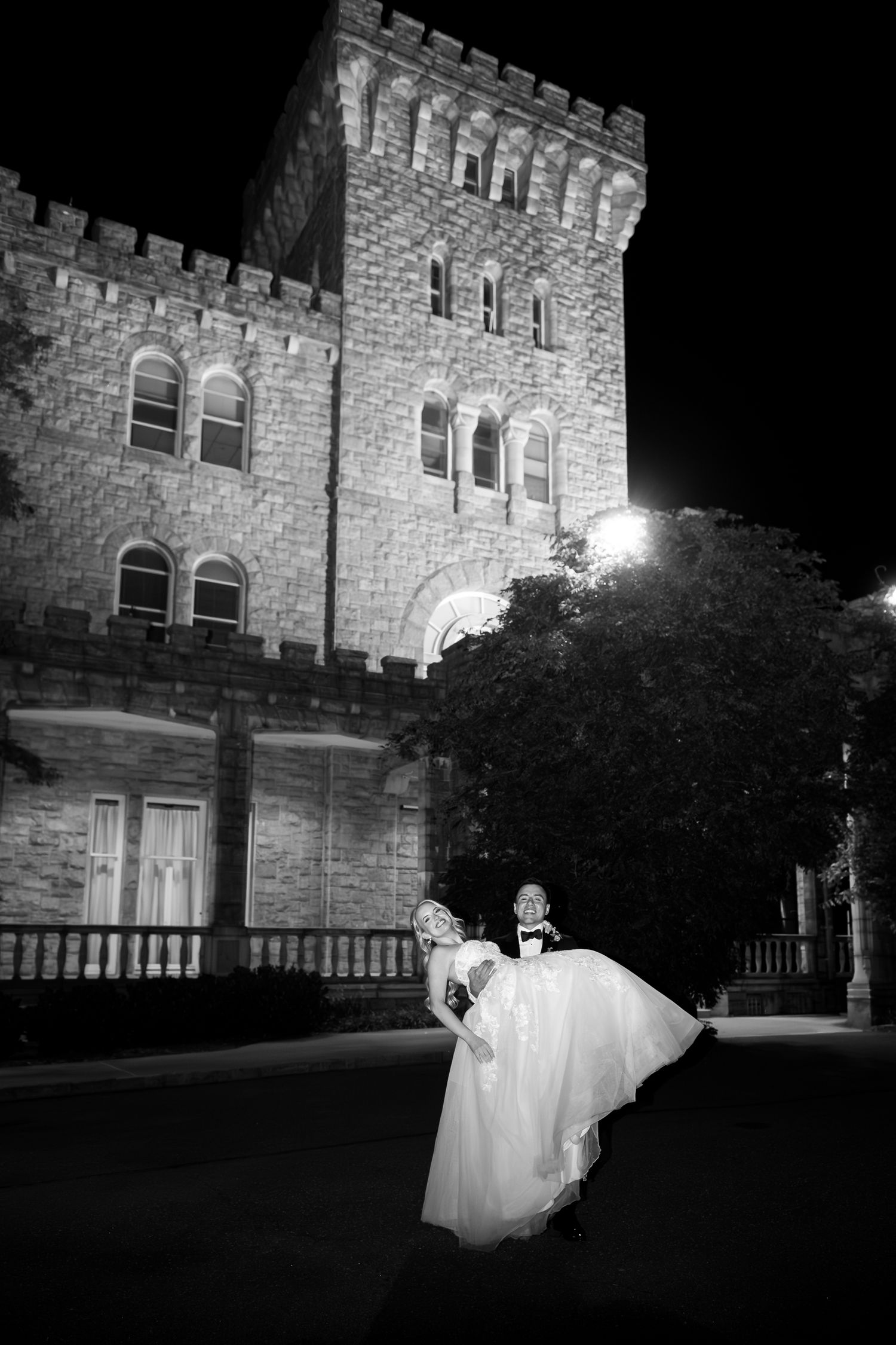 A ghostly figure in white appears in front of a stone castle at night in a spooky Halloween scene.