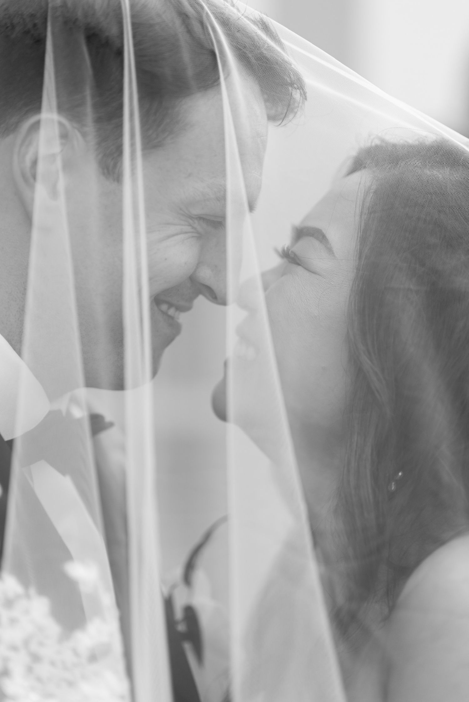 Artistic black and white photograph showing ethereal wedding veil details.