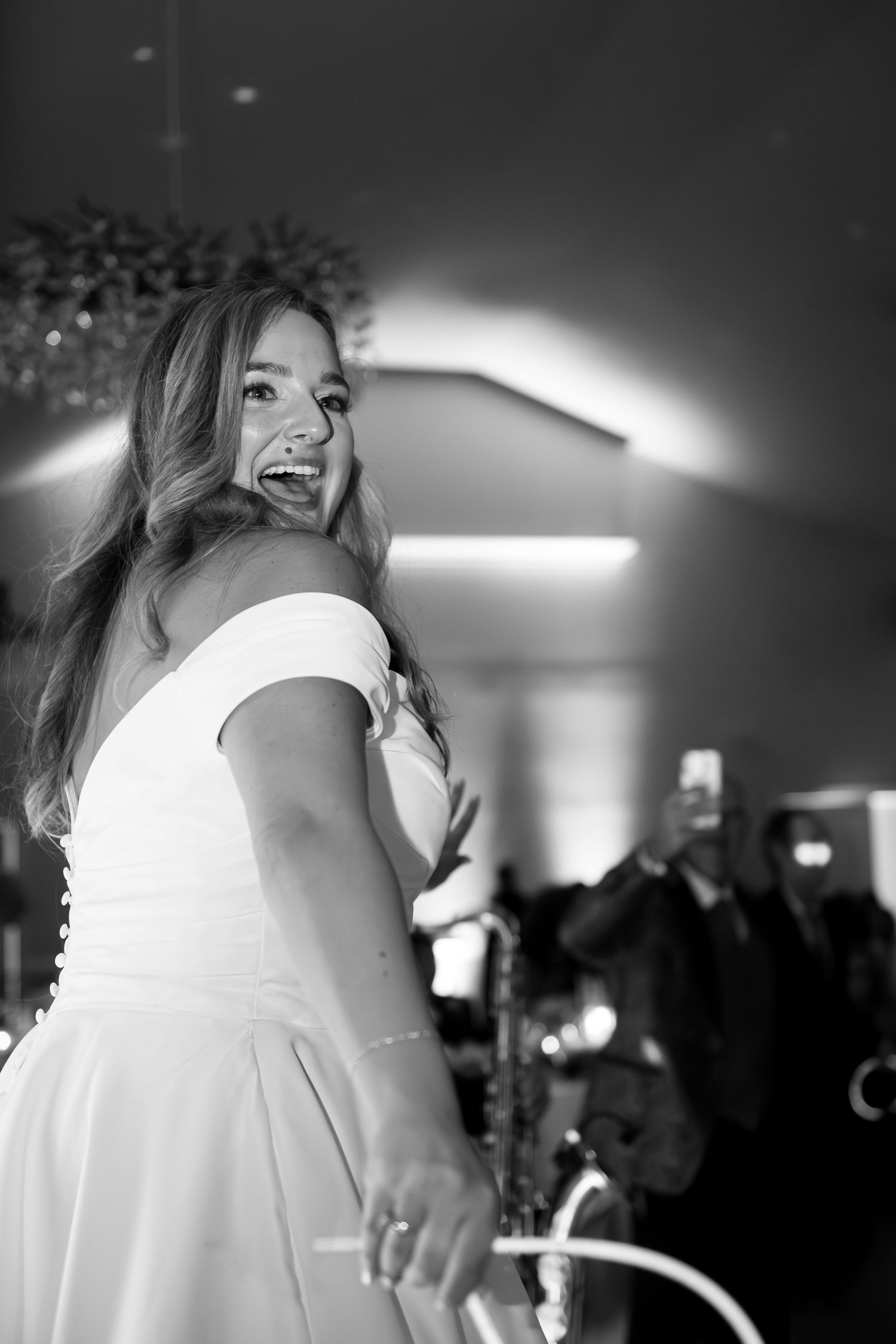 Black and white candid shots of dancing and celebration at a wedding reception.