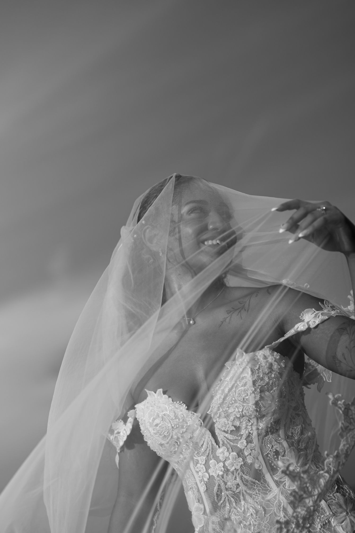 Black and white close-up of intricate lace details on a wedding veil.