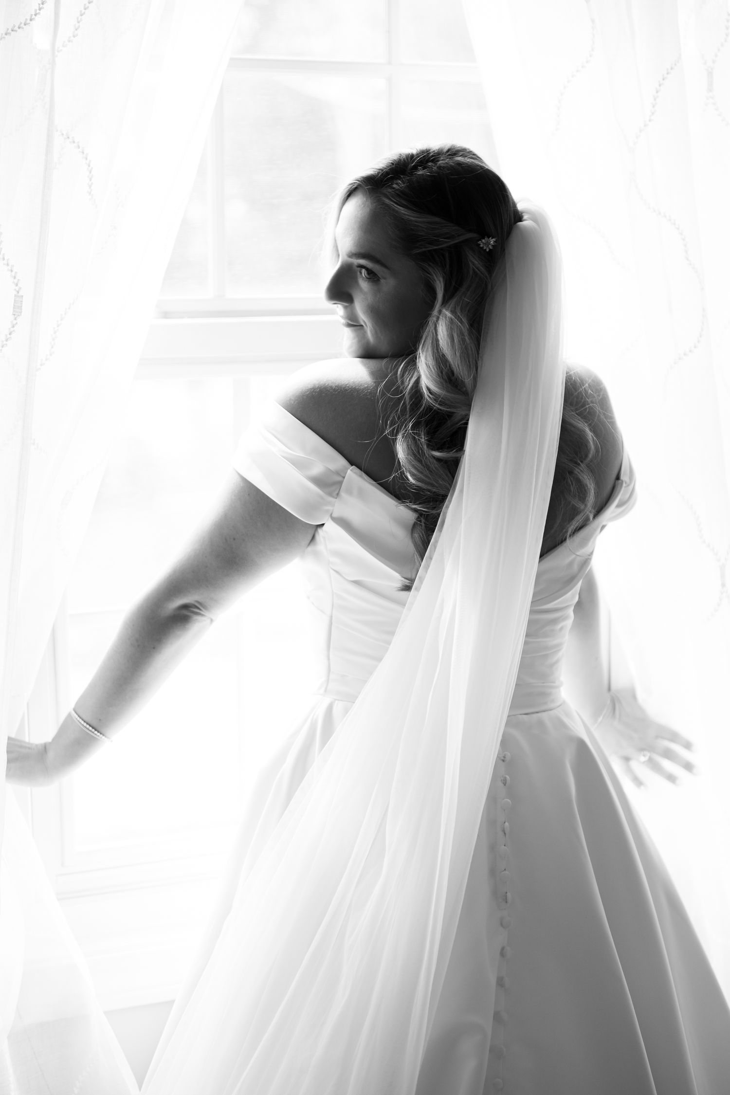 Artistic black and white series of a bride in flowing white dress and veil.